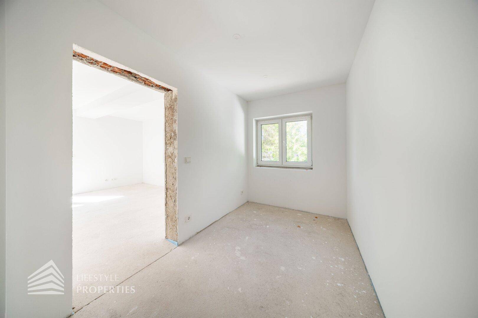 Kleiner, heller Raum im Rohbau mit Fenster, ideal als Schlaf- oder Arbeitszimmer.