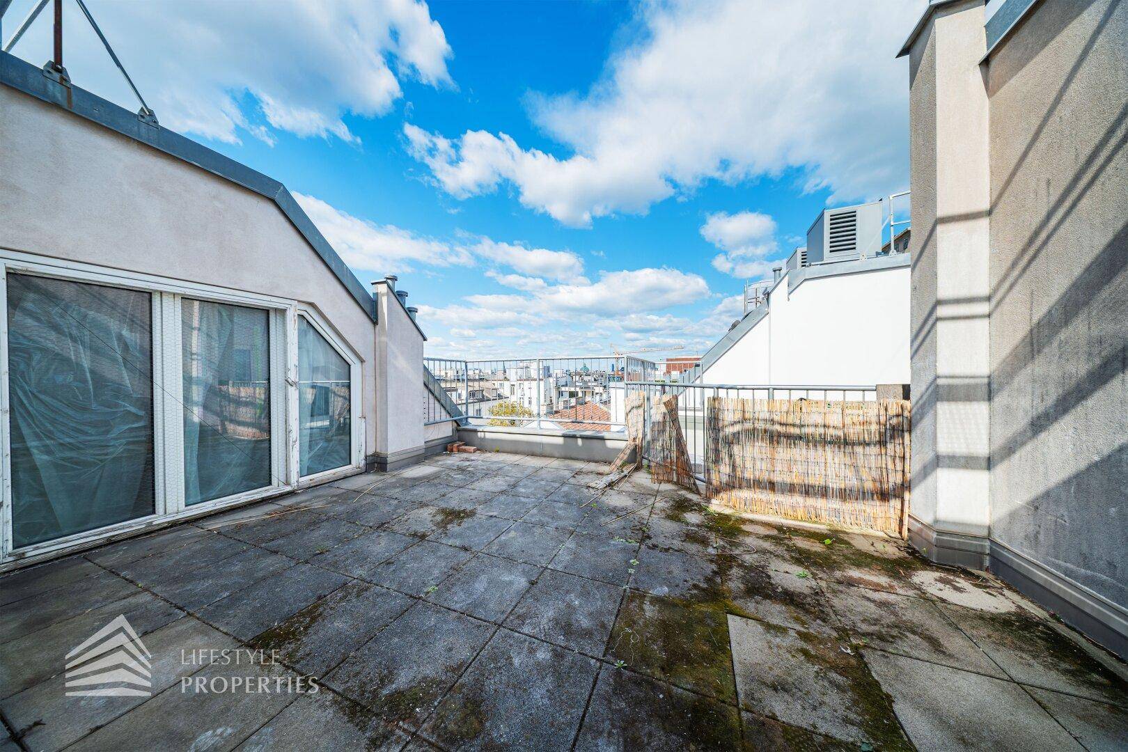 Dachterrasse im Rohzustand mit Blick über die Stadt und viel Potenzial.