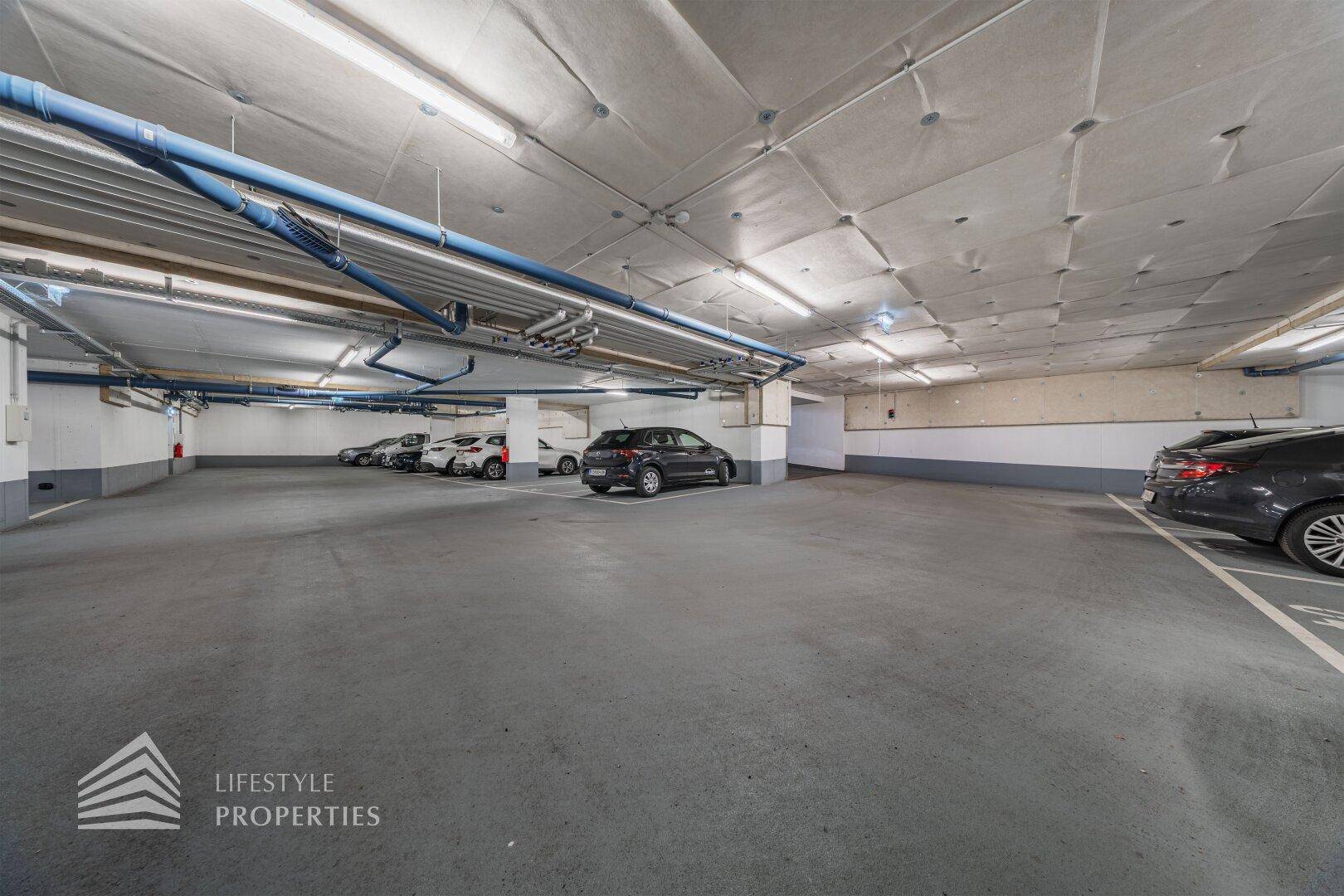 Geräumige Tiefgarage mit mehreren Stellplätzen für Fahrzeuge und guter Beleuchtung.
