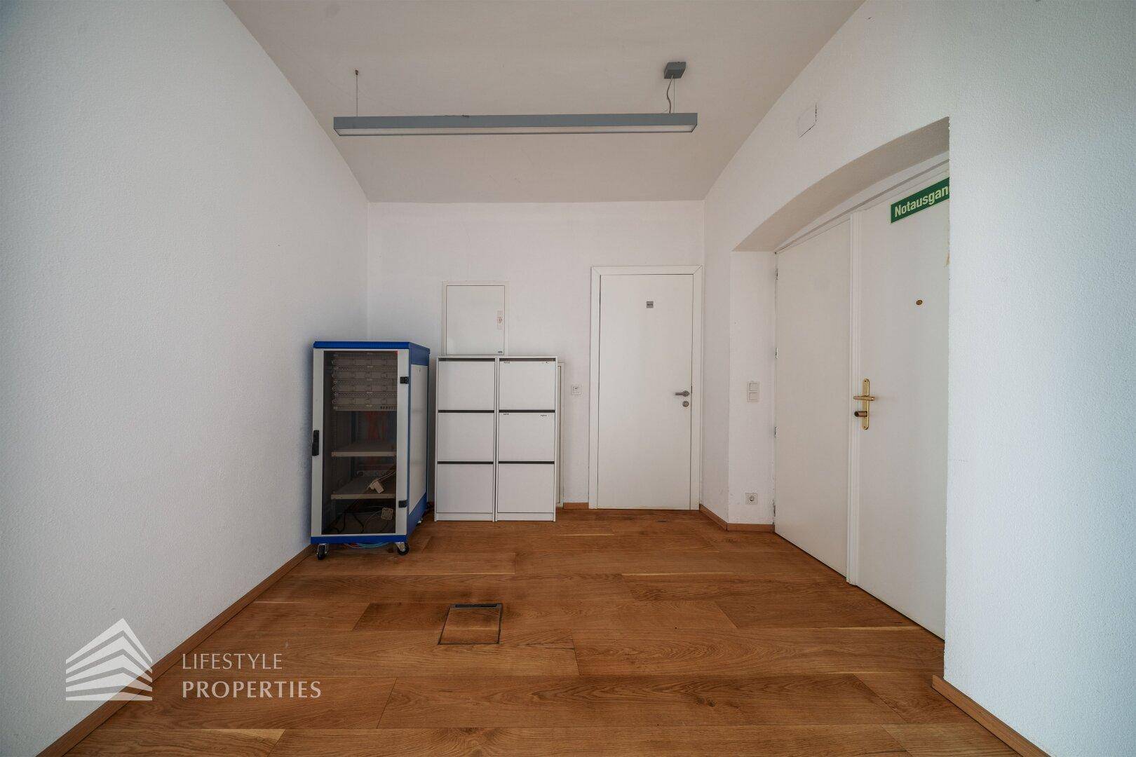 Flur mit Holzboden, weißen Wänden und praktischen Lagermöglichkeiten.