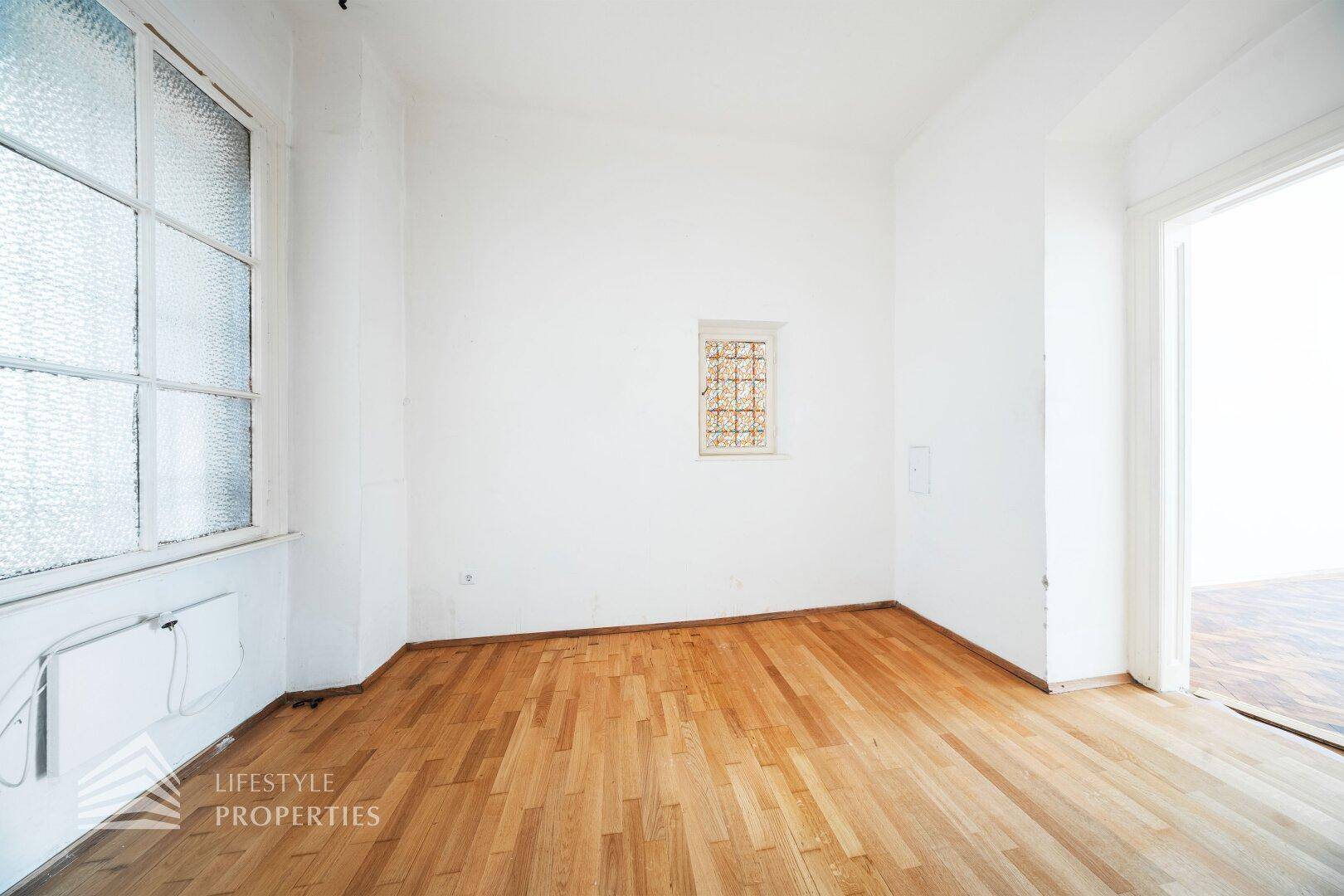 Heller Raum mit Holzboden und großen Fenstern, bietet viel Tageslicht und Gestaltungsmöglichkeiten.