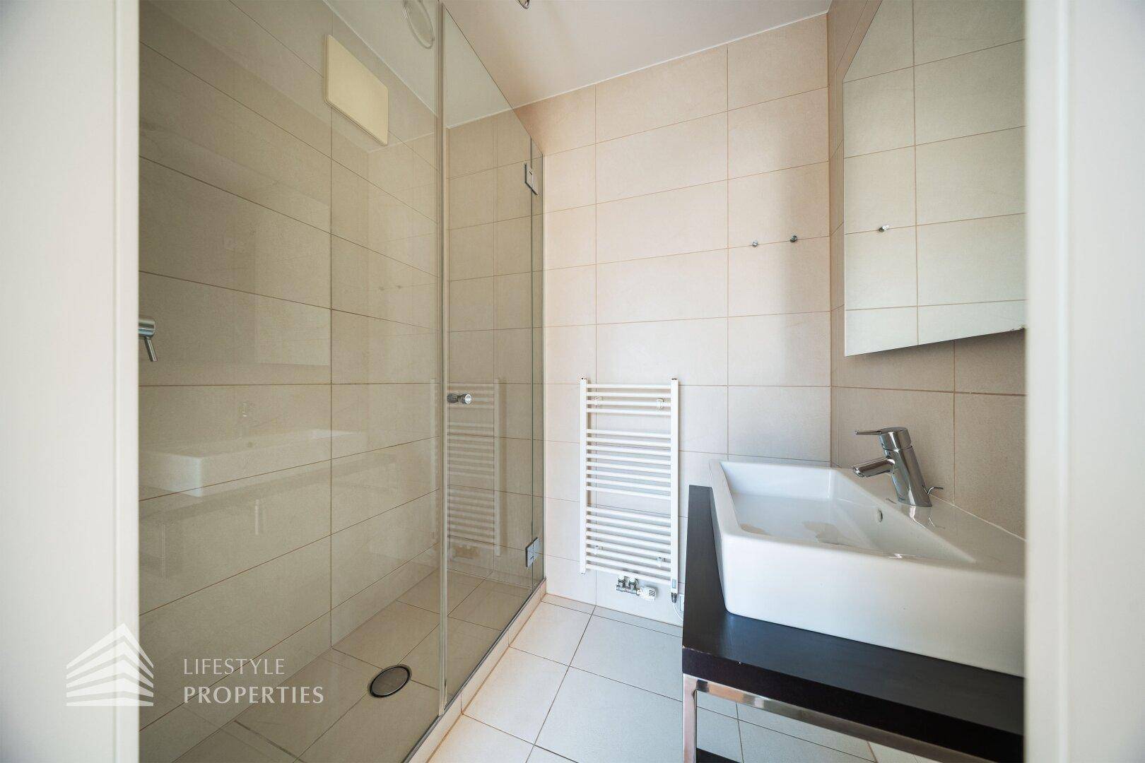 Modernes Badezimmer mit begehbarer Dusche, Wand-WC und beheiztem Handtuchhalter.