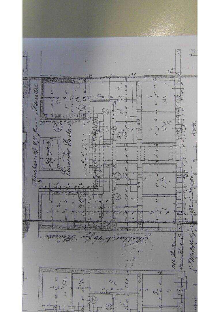 Detaillierter historischer Grundriss mit verschiedenen Räumen und architektonischen Merkmalen.