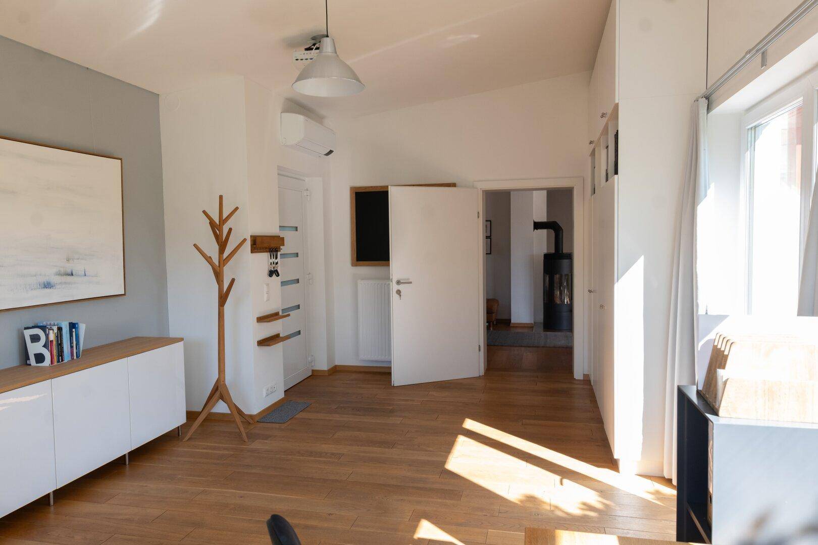 Geräumiger Flur mit Holzboden, moderner Einrichtung und Zugang zu weiteren Räumen.