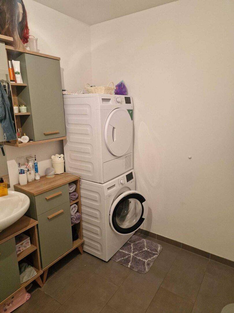 Badezimmer mit Waschmaschine und Trockner, integriert in die Einrichtung.