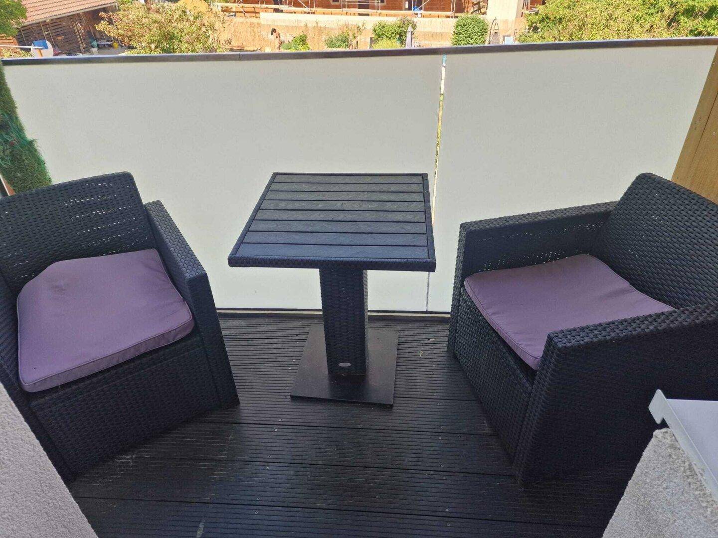 Kleiner Balkon mit gemütlichen Sitzgelegenheiten und Sichtschutz.