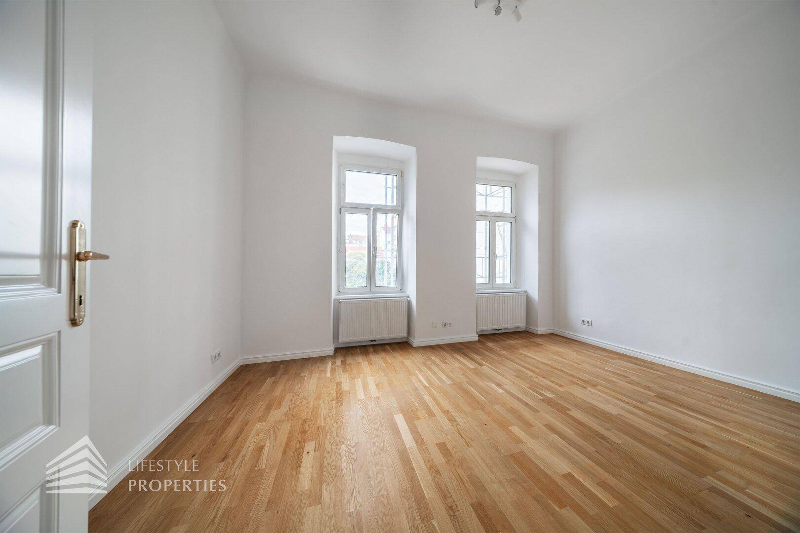 Helles Zimmer mit Parkettboden und zwei Fenstern, ideal als Schlafzimmer oder Arbeitszimmer nutzbar.