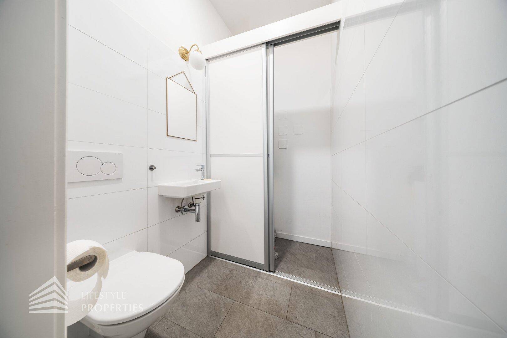 Kleines Gäste-WC mit modernem Design, wandhängender Toilette und Waschbecken.
