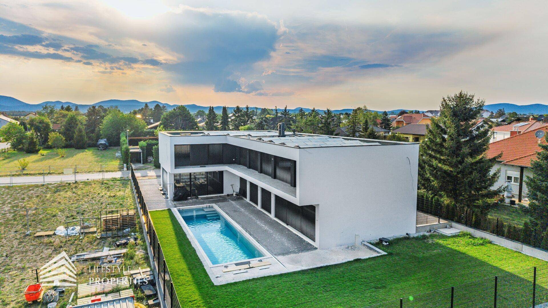 Zeitgenössische Villa mit Pool und weitläufigem Blick auf die umliegende Landschaft und Berge.