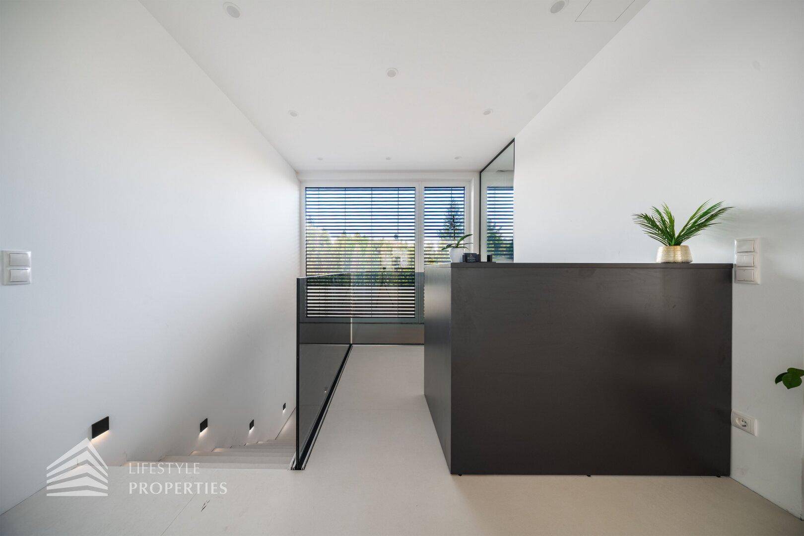 Moderner Flur mit minimalistischem Design, heller Boden und Blick auf die Umgebung.