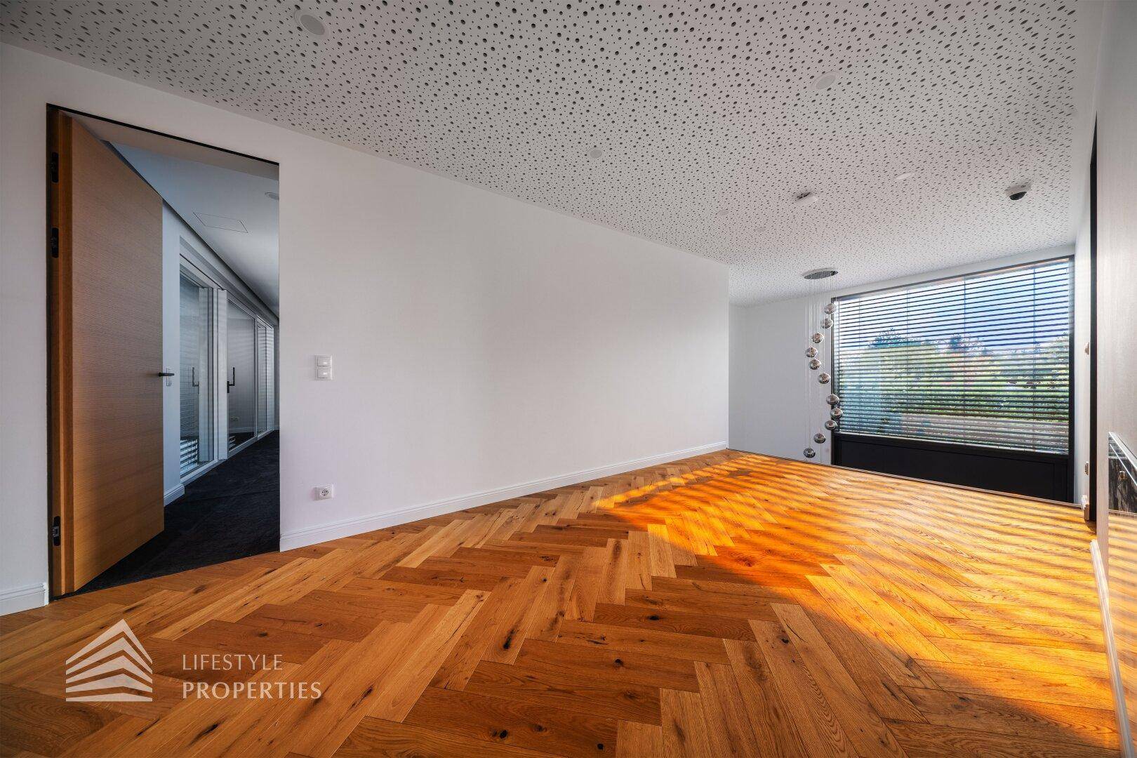 Helles Zimmer mit Fischgrätparkett und großem Fenster, ideal als Schlaf- oder Arbeitszimmer.