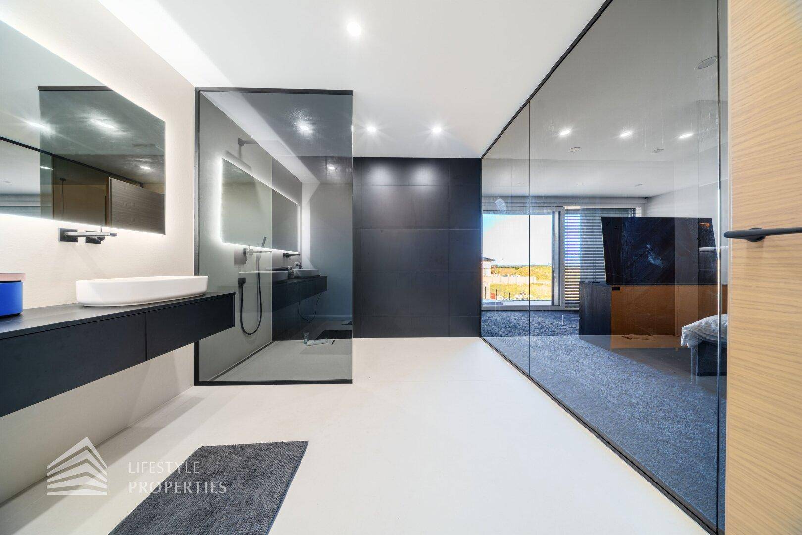 Luxuriöses Badezimmer mit Glaswänden, Doppelwaschbecken und modernem Design.