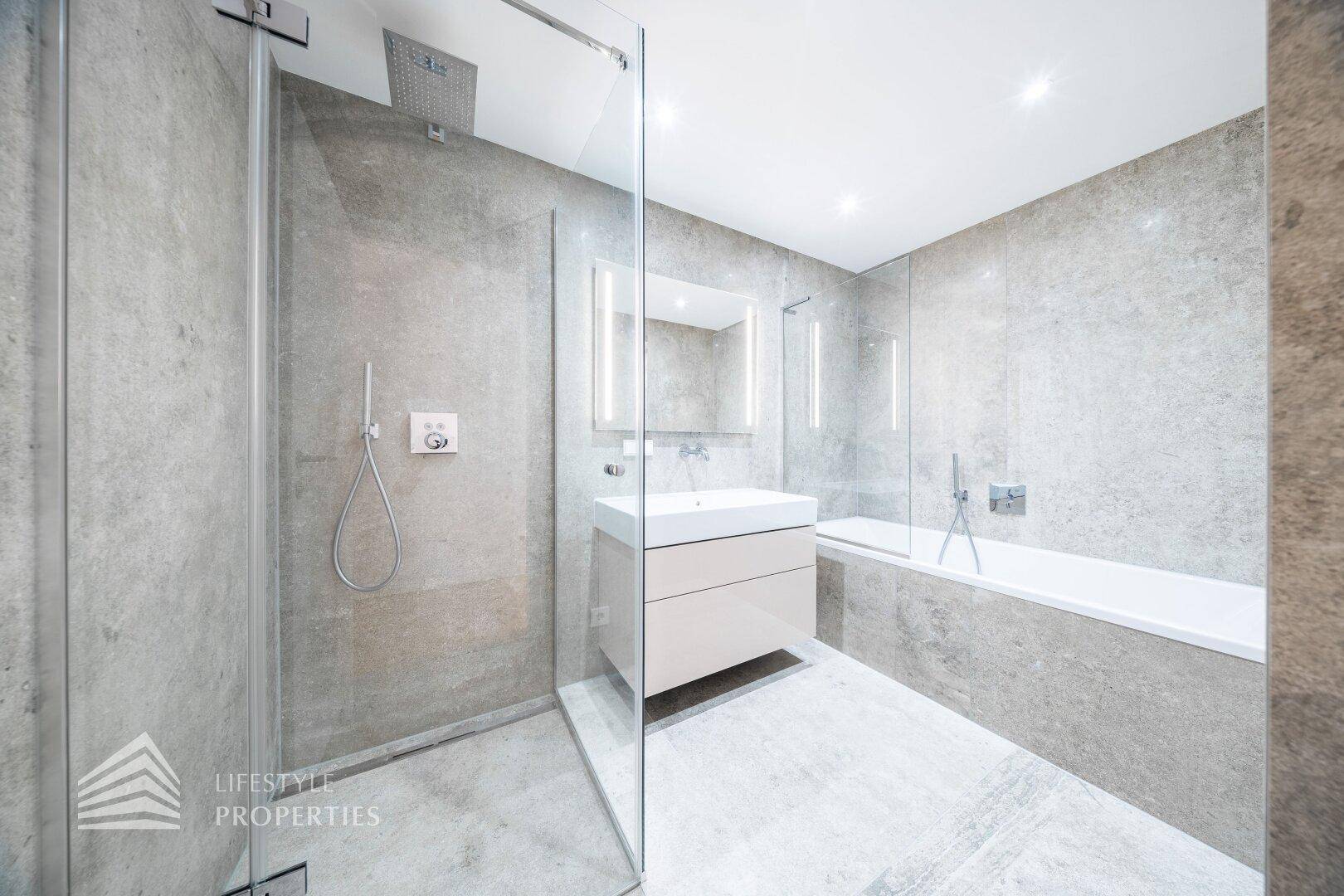 Modernes Badezimmer mit grauen Fliesen, begehbarer Dusche, Badewanne und Einzelwaschbecken.