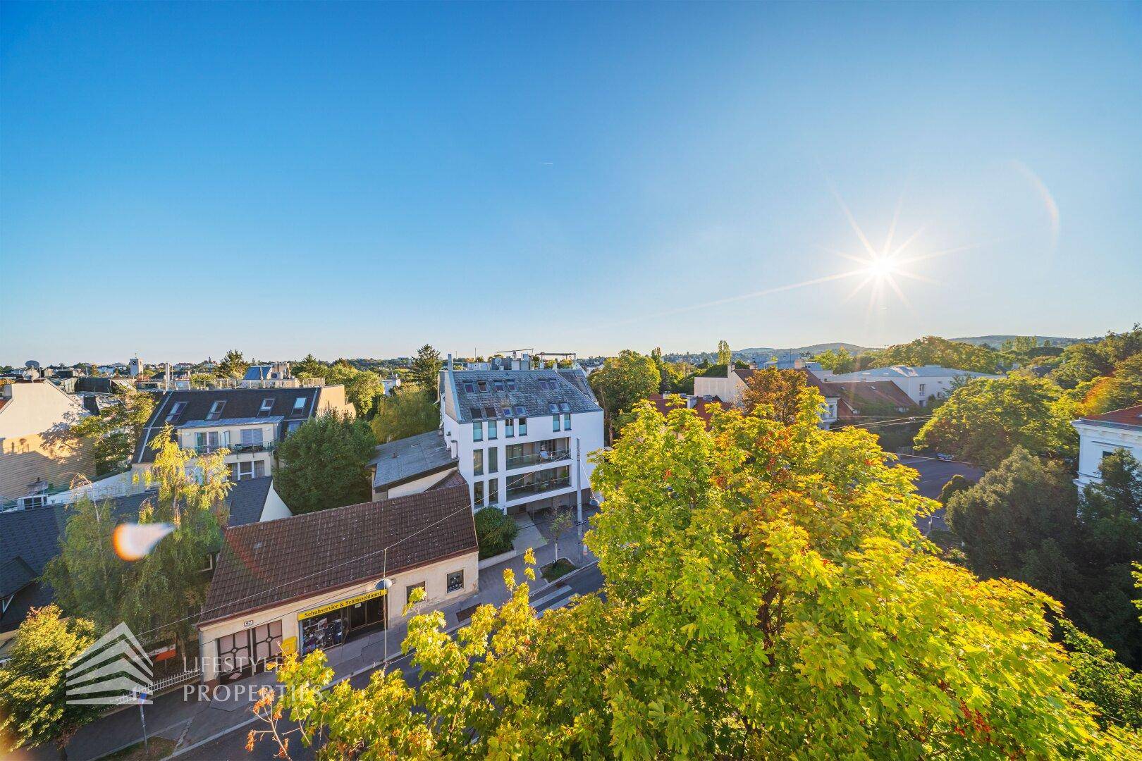 Sonniger Balkon mit weitem Blick über die Stadt und die umliegende Landschaft, sehr hell.