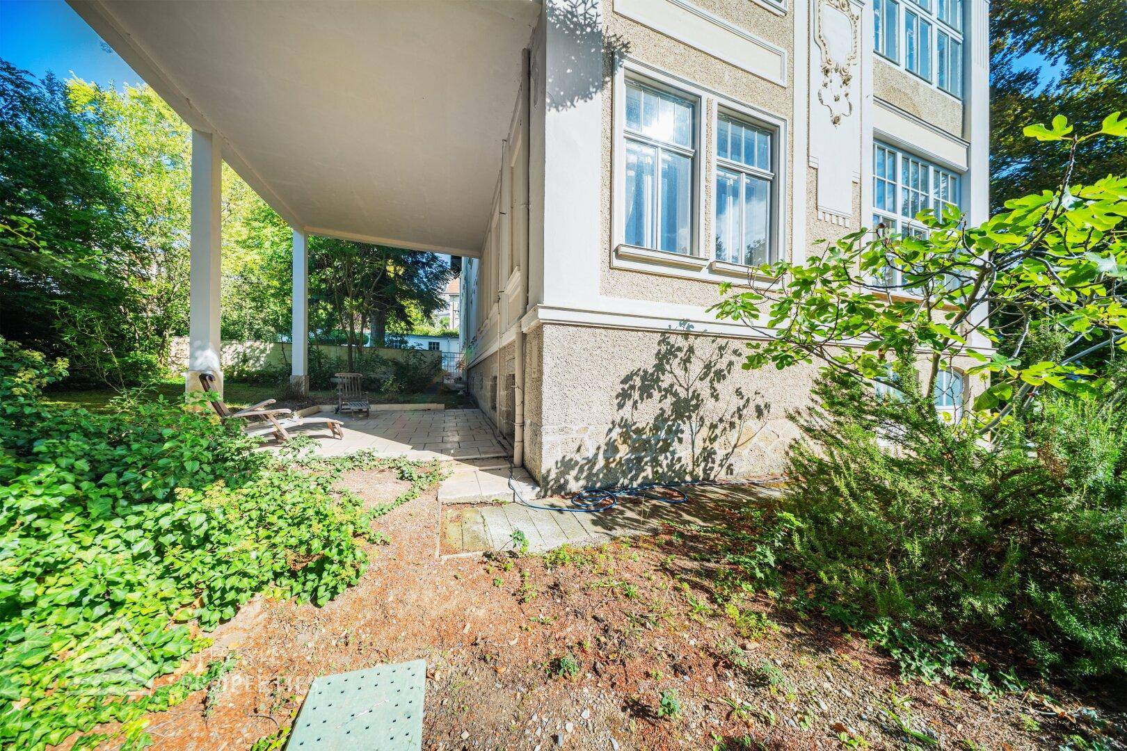 Überdachter Außenbereich mit Blick auf den Garten, ideal für entspannte Stunden im Freien.