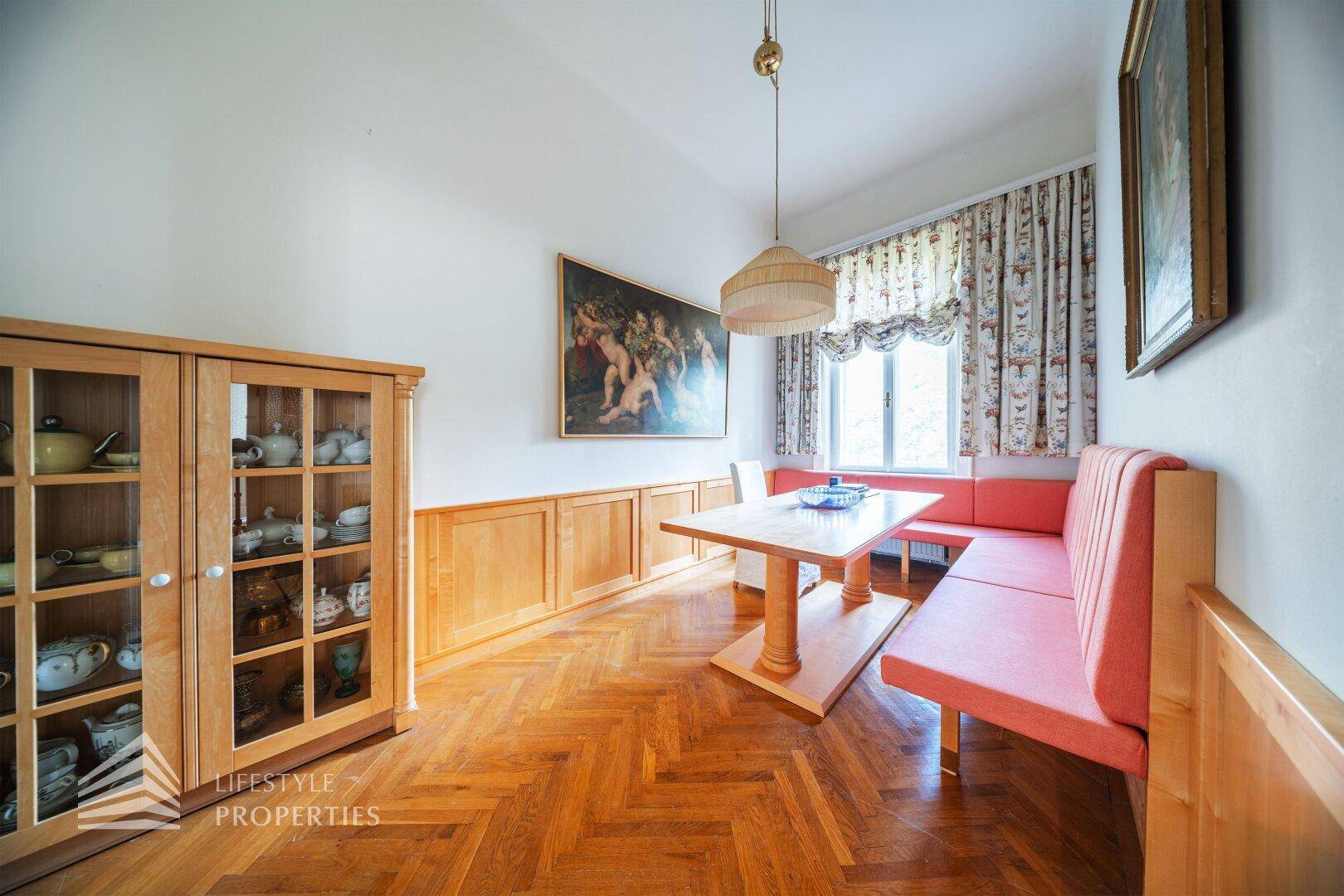 Traditioneller Essbereich mit Holzvertäfelung, Fischgrätparkett und gemütlicher Sitzbank.