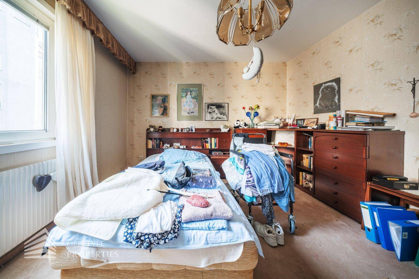 Schlafzimmer mit Teppichboden, Bett und Fenster mit Blick nach draußen.