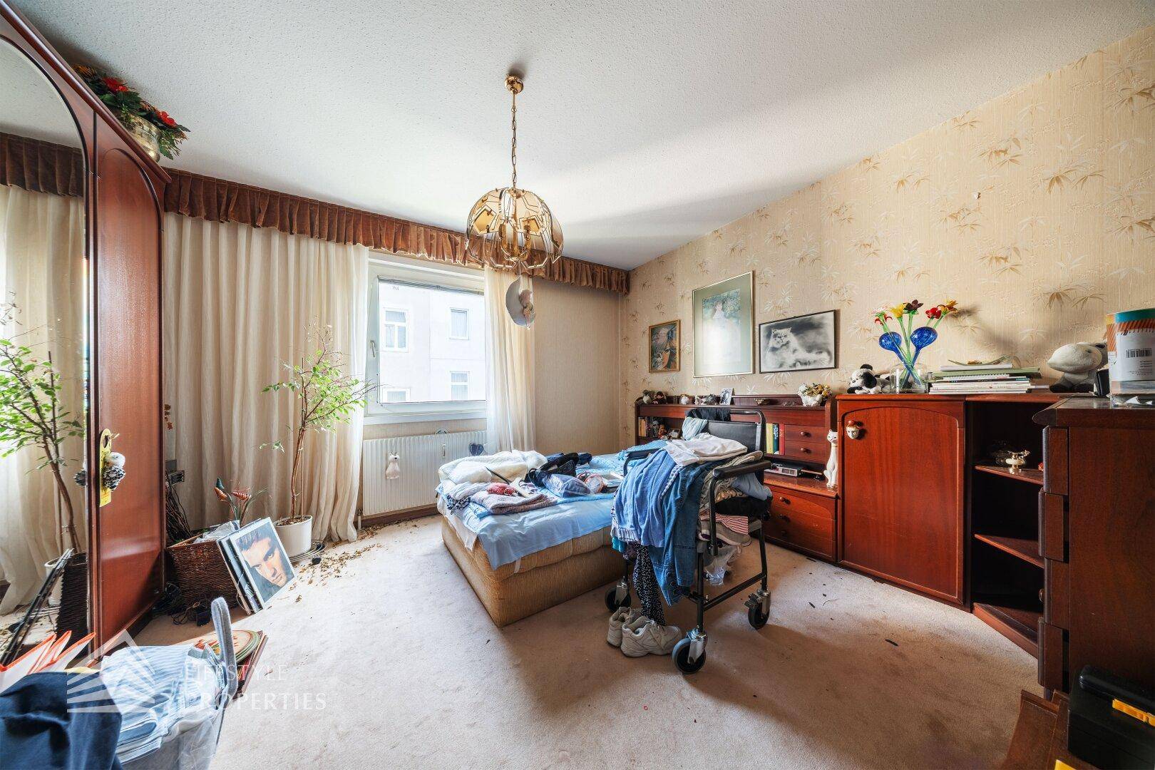 Schlafzimmer mit Teppichboden, Fenster und traditioneller Tapete.