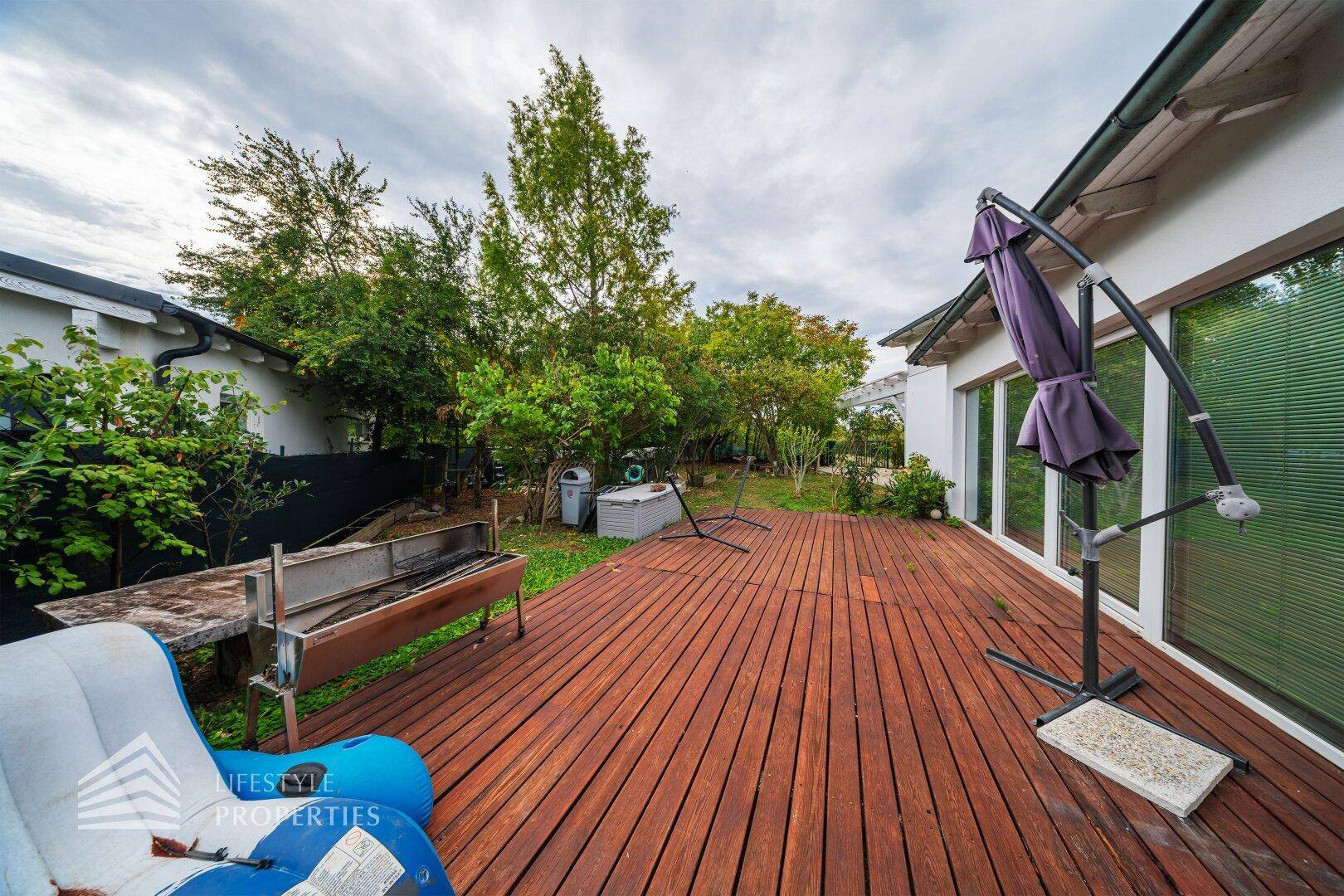 Weitläufige Holzterrasse mit Grill und viel Platz für Outdoor-Aktivitäten.