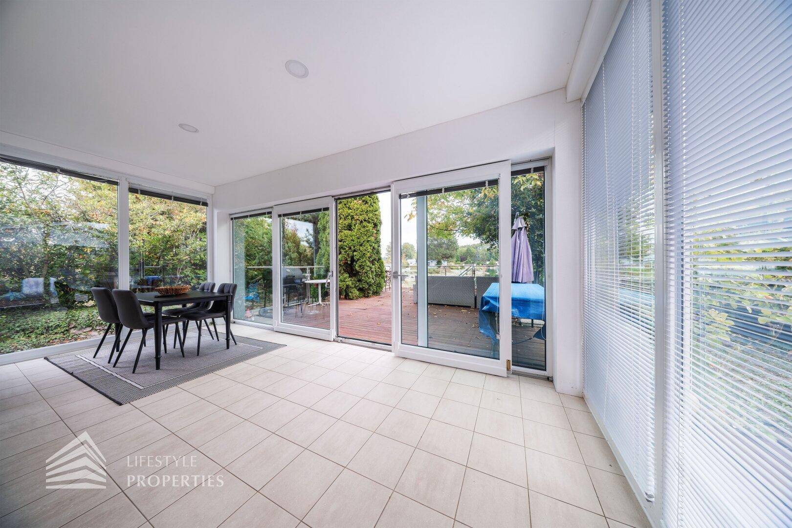 Essbereich mit großen Fensterfronten, Fliesenboden und direktem Zugang zur Terrasse.