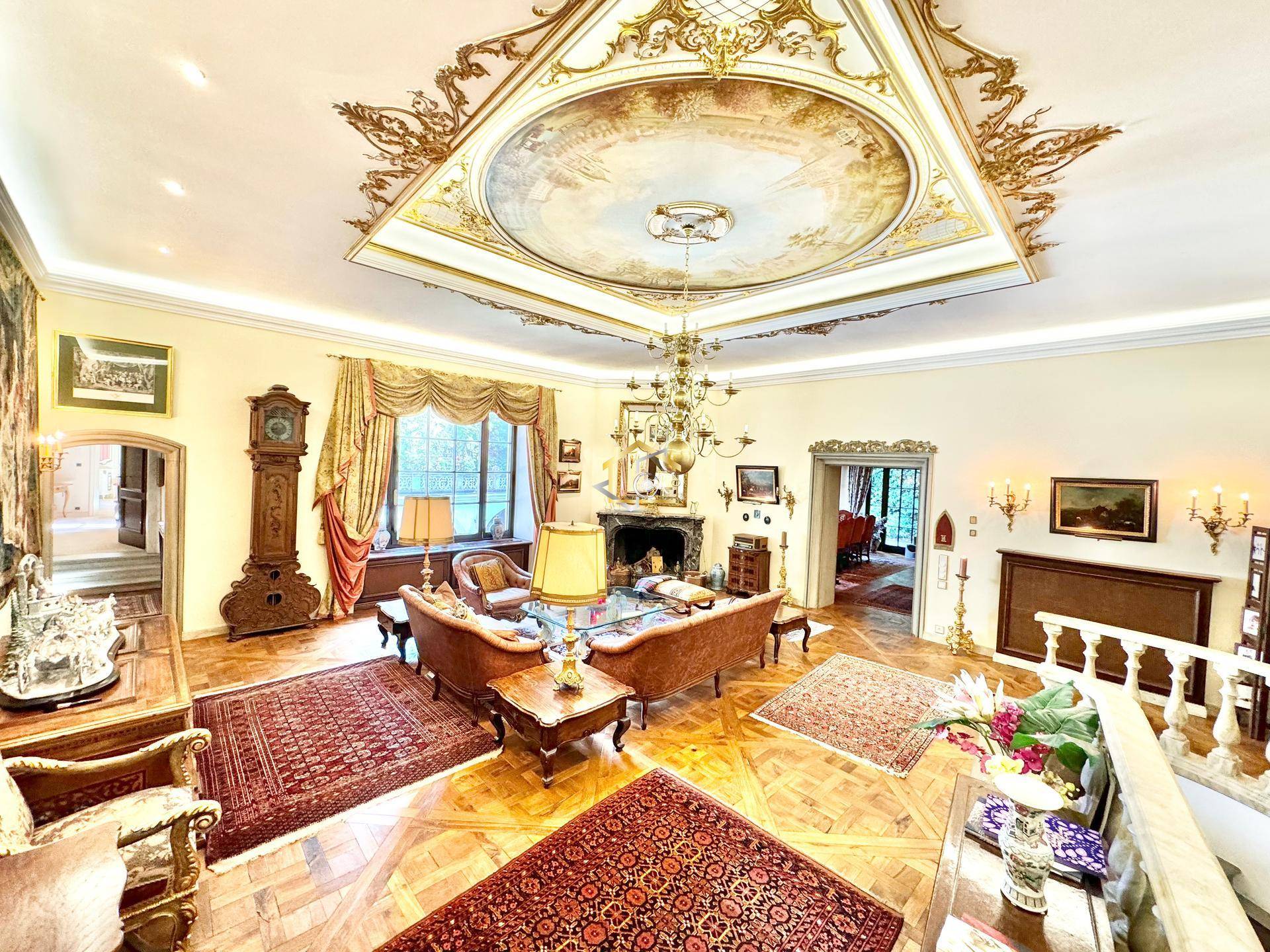 Prunkvolles Wohnzimmer mit kunstvoller Deckenmalerei, Parkettboden und eleganter Einrichtung.