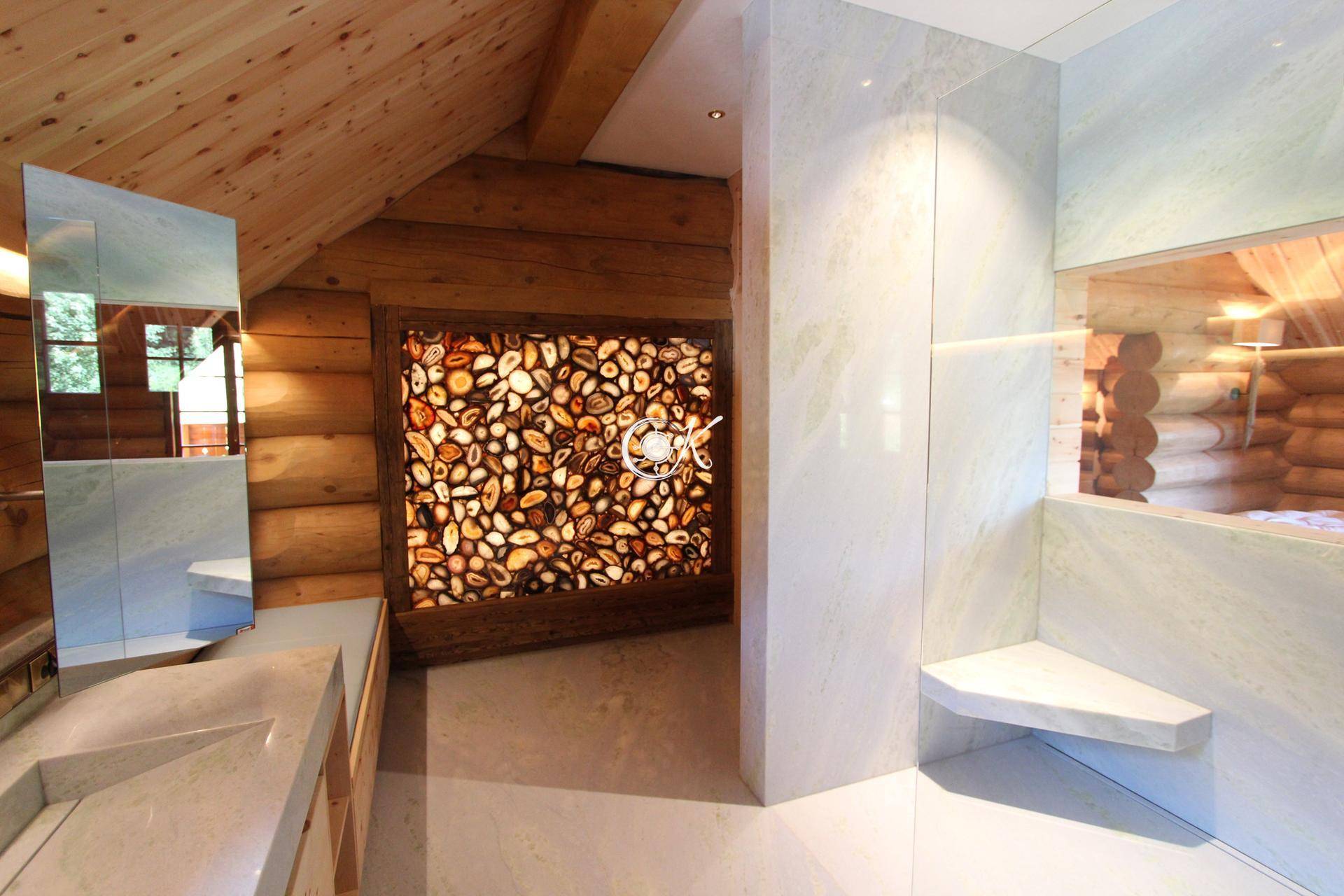 Modernes Badezimmer mit Holzwänden, großformatigen Fliesen und einer beleuchteten Steinwand.