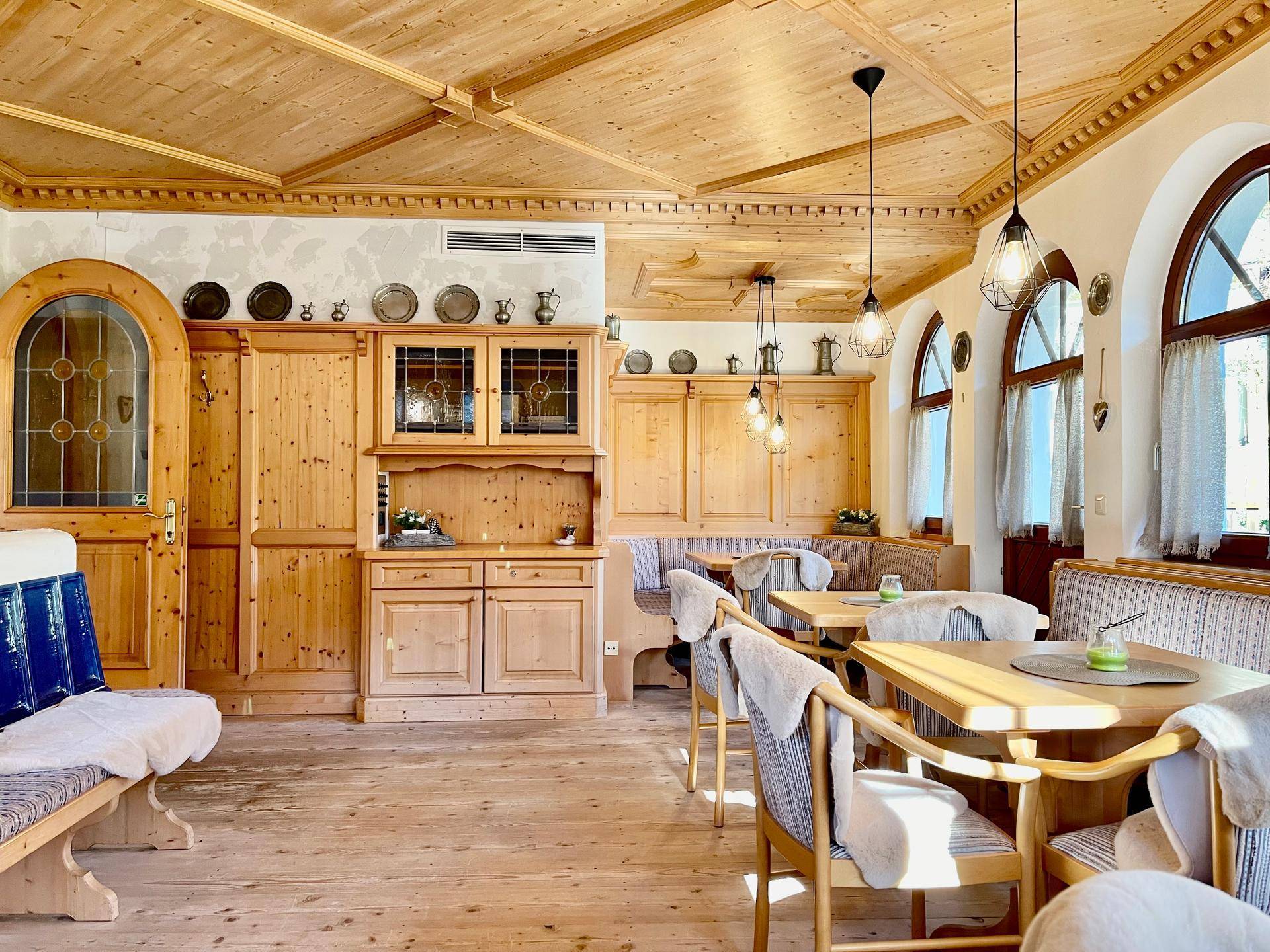 Gemütlicher Speisesaal im alpinen Stil mit Holzvertäfelung, Holzboden und traditionellen Sitzbänken.