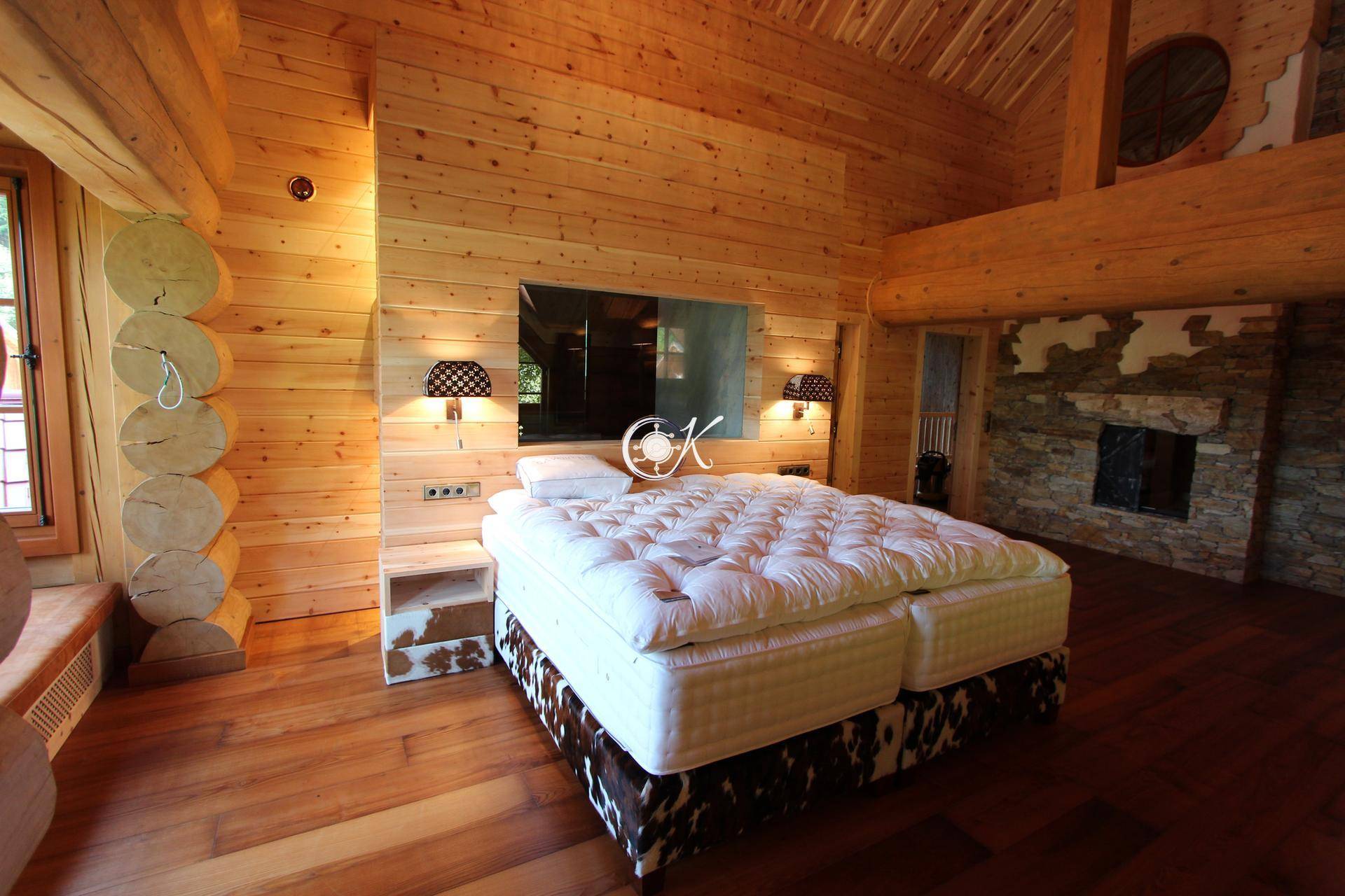 Geräumiges Schlafzimmer mit Holzwänden, Holzboden und einem großen Doppelbett.