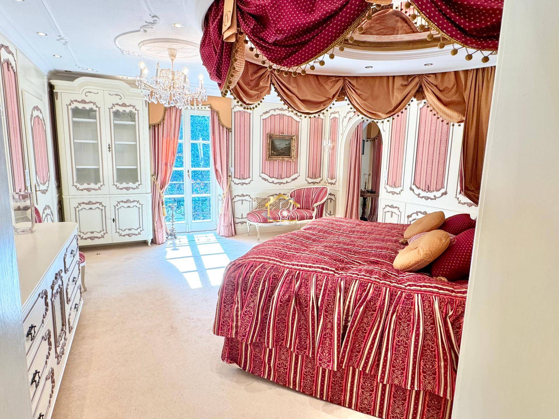 Opulentes Schlafzimmer im Barockstil mit Himmelbett, schweren Vorhängen und Stuckdecke.