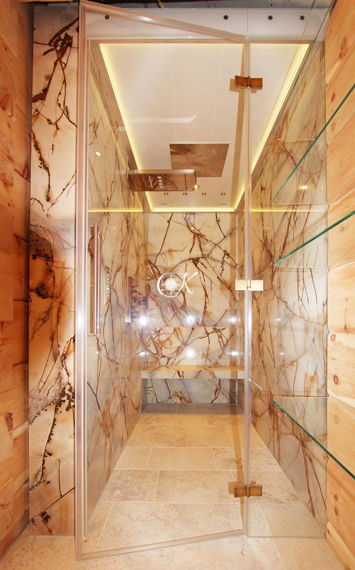 Elegante Duschkabine mit Steinverkleidung und indirekter Beleuchtung in einem luxuriösen Badezimmer.