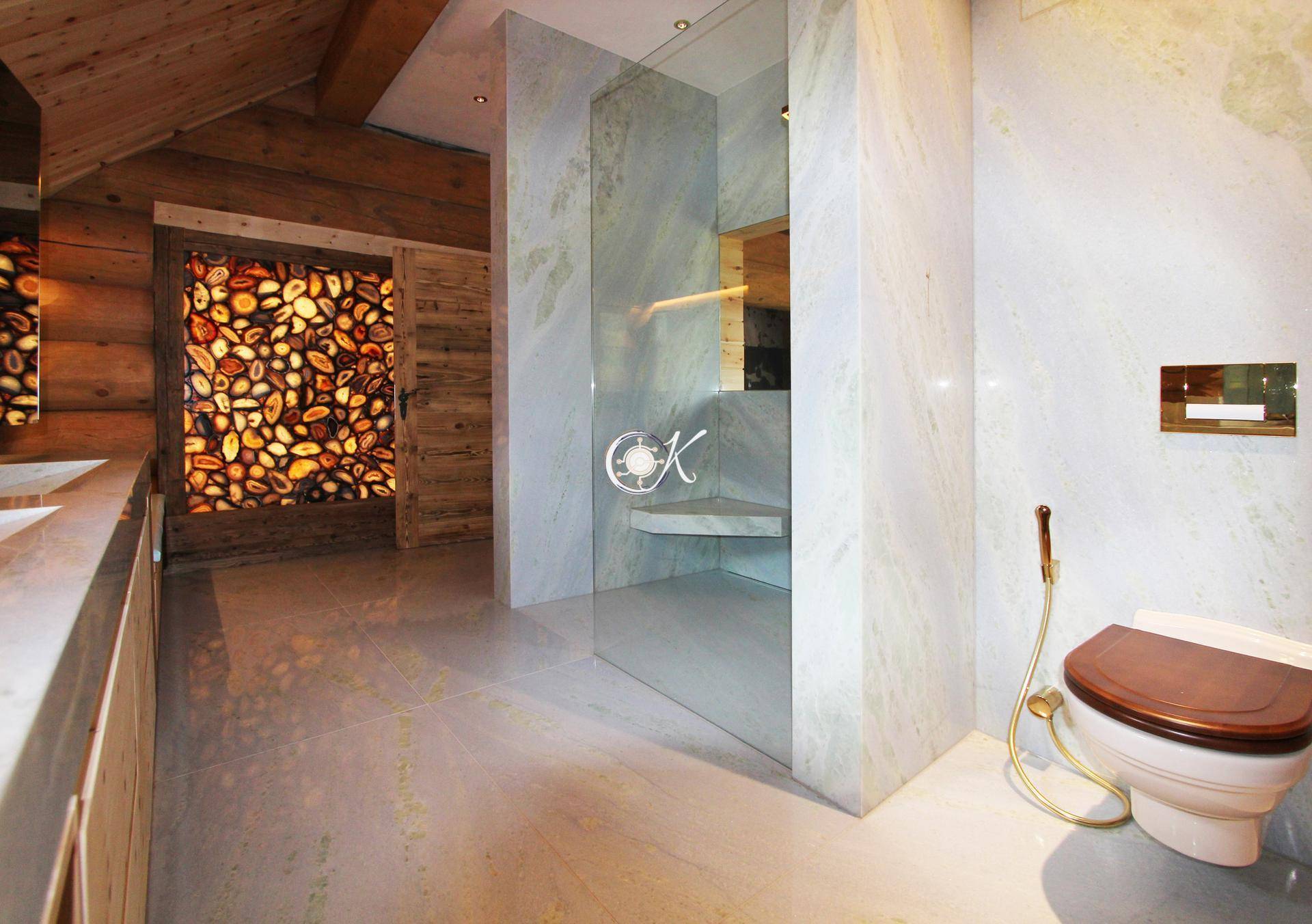 Modernes Badezimmer mit Duschkabine, WC und beleuchteter Steinwand.