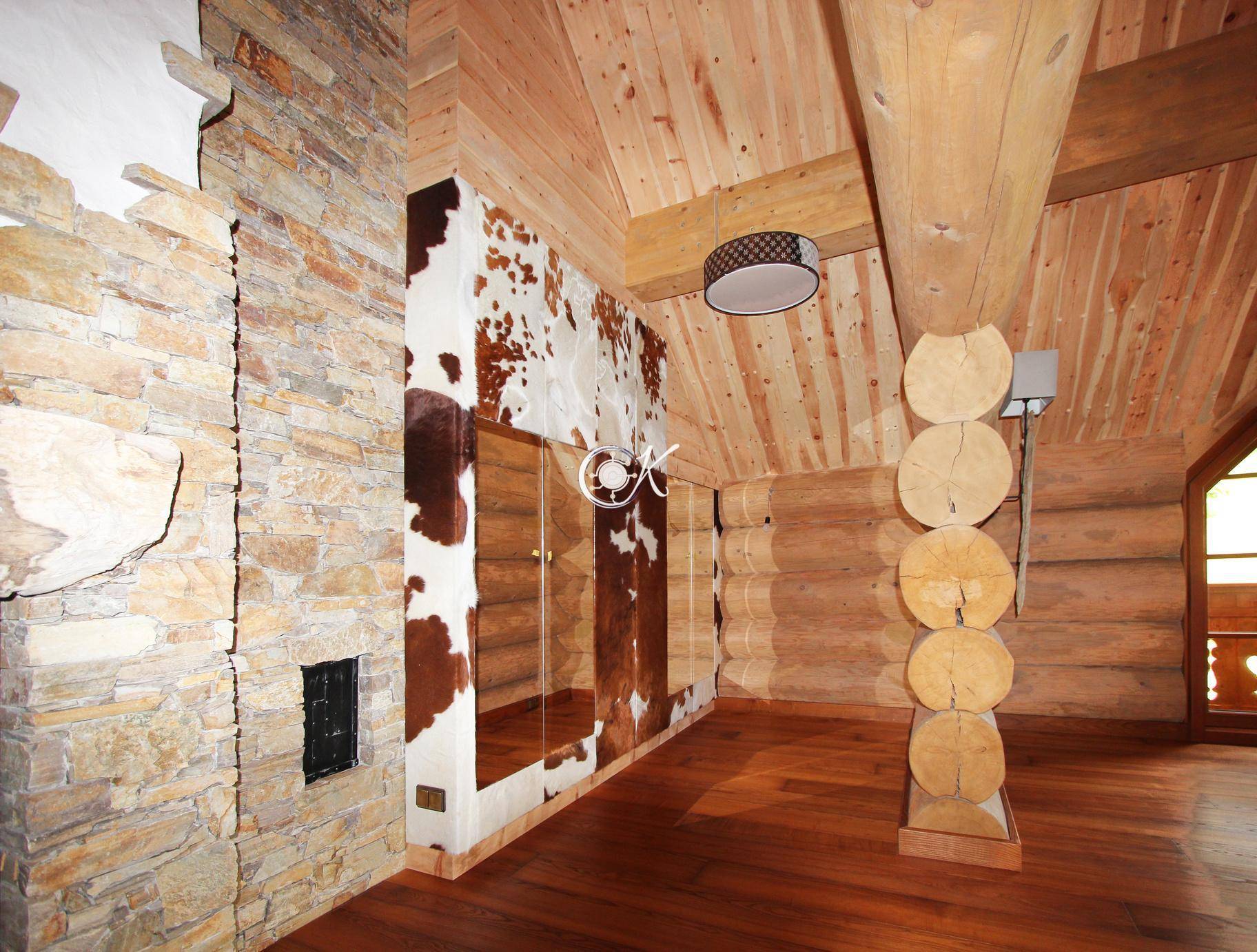 Geräumiger Raum mit Holzwänden, Steinwand und einem großen Spiegel.