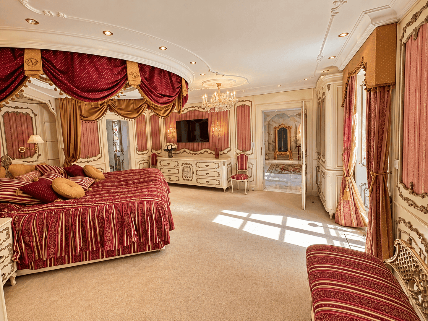 Opulentes Schlafzimmer mit Himmelbett, Stuckdecke und Zugang zu einem weiteren Raum.