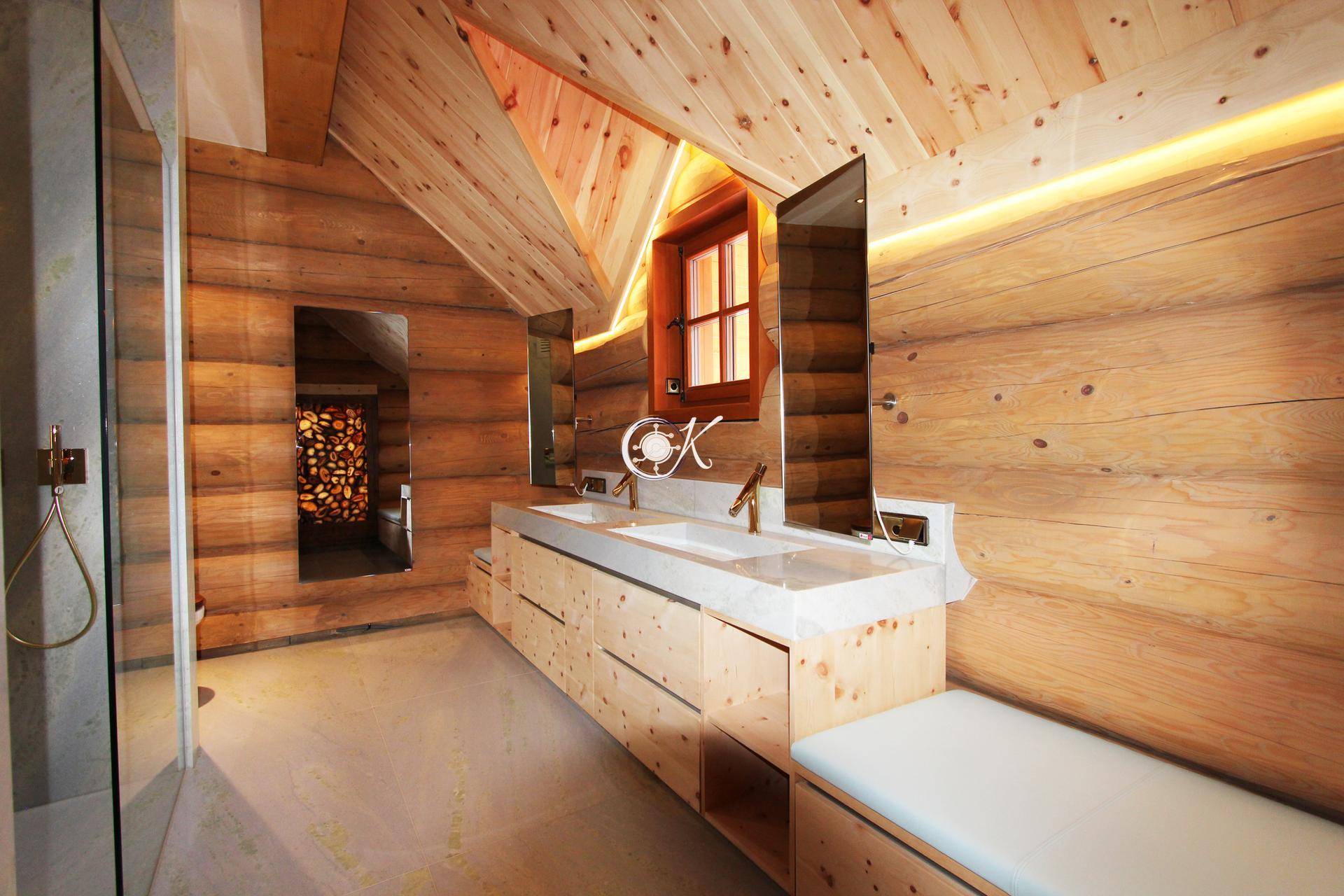 Helles Badezimmer mit Doppelwaschbecken, Holzelementen und großer Duschkabine.
