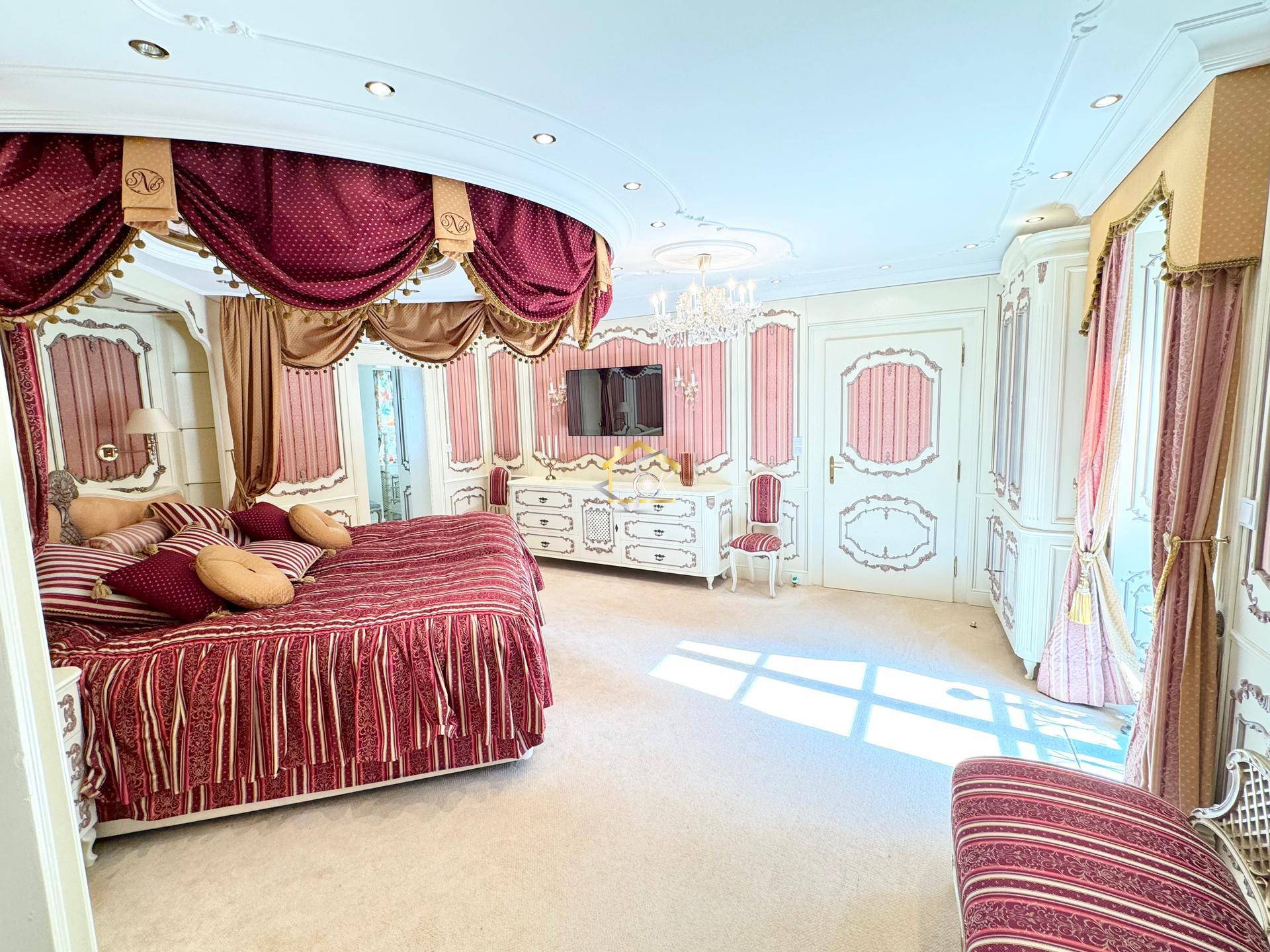 Luxuriöses Schlafzimmer mit opulentem Himmelbett, eleganten Möbeln und Stuckdecken.
