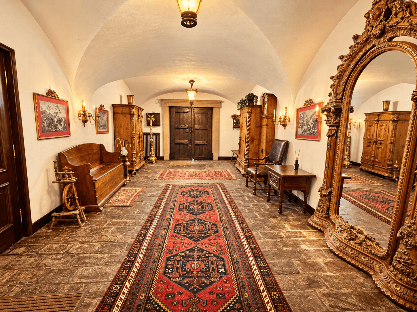 Langer Flur mit Gewölbedecke, Steinfliesenboden und antiken Holzmöbeln sowie opulenten Teppichen.