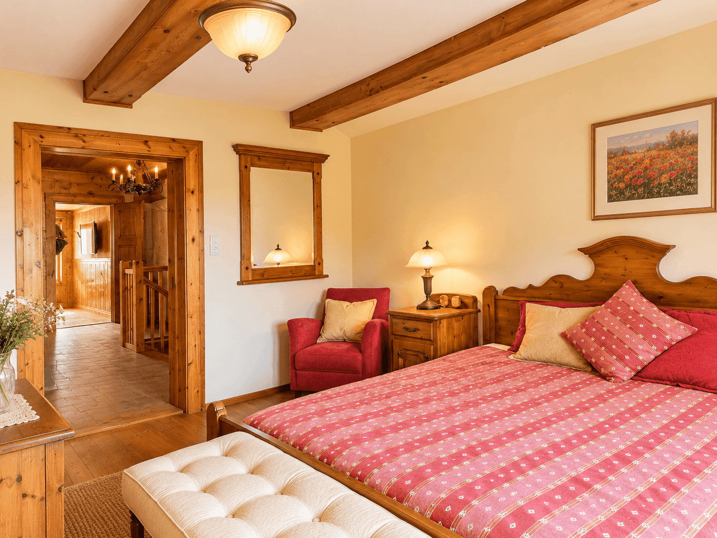 Helles Schlafzimmer mit Holzmöbeln, Holzbalken und Zugang zum Flur.