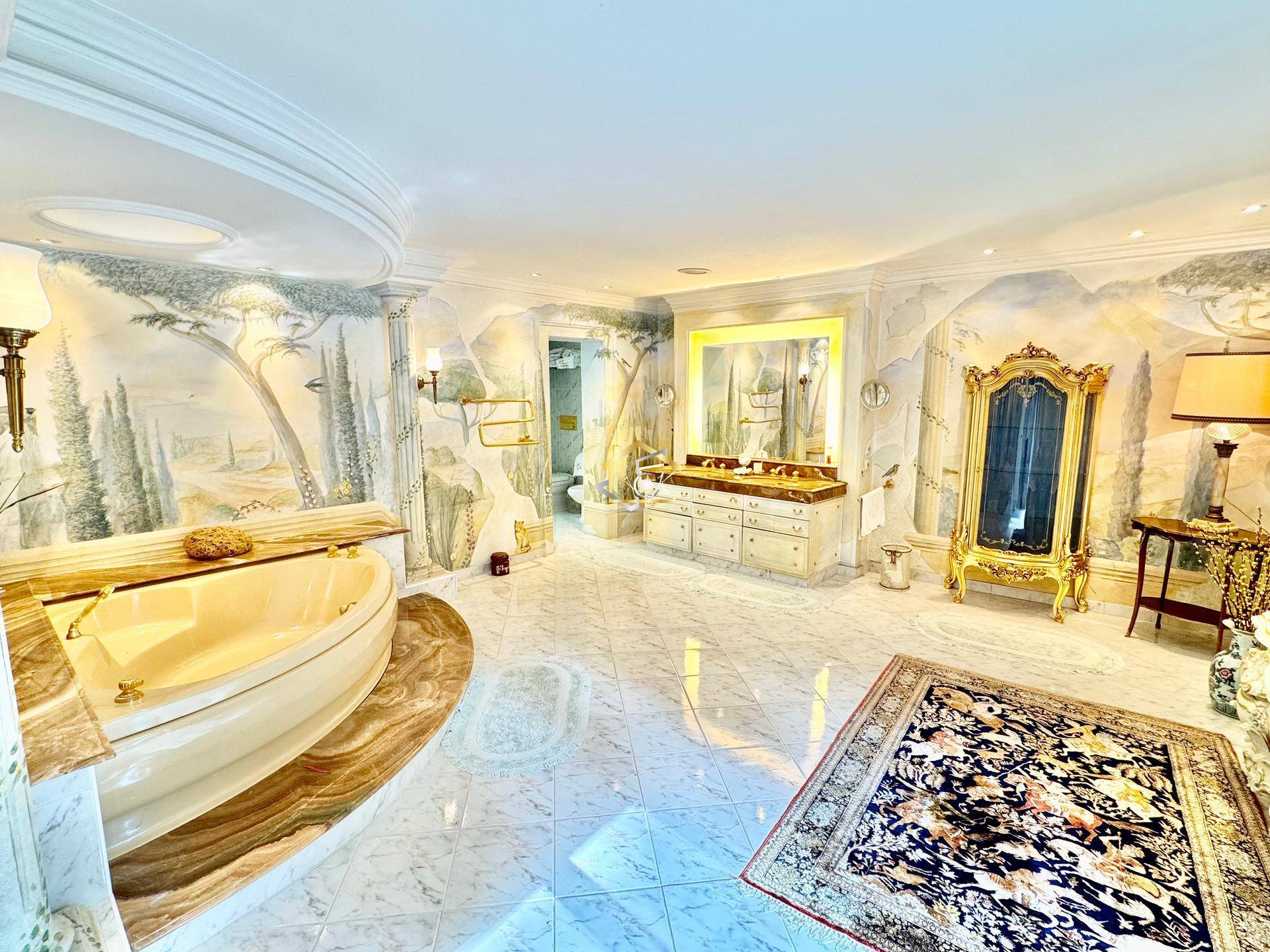 Opulentes Badezimmer mit Marmorboden, freistehender Badewanne und Wandmalereien.