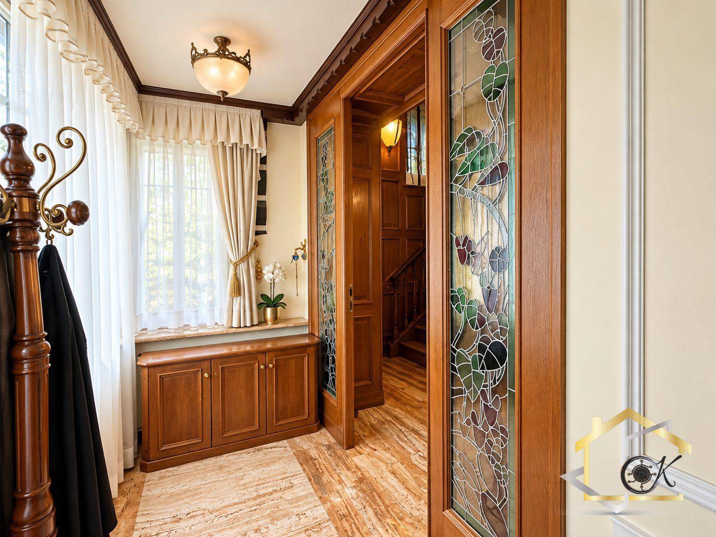 Einladender Flur mit Holzvertäfelung, Buntglasfenstern und Garderobe.