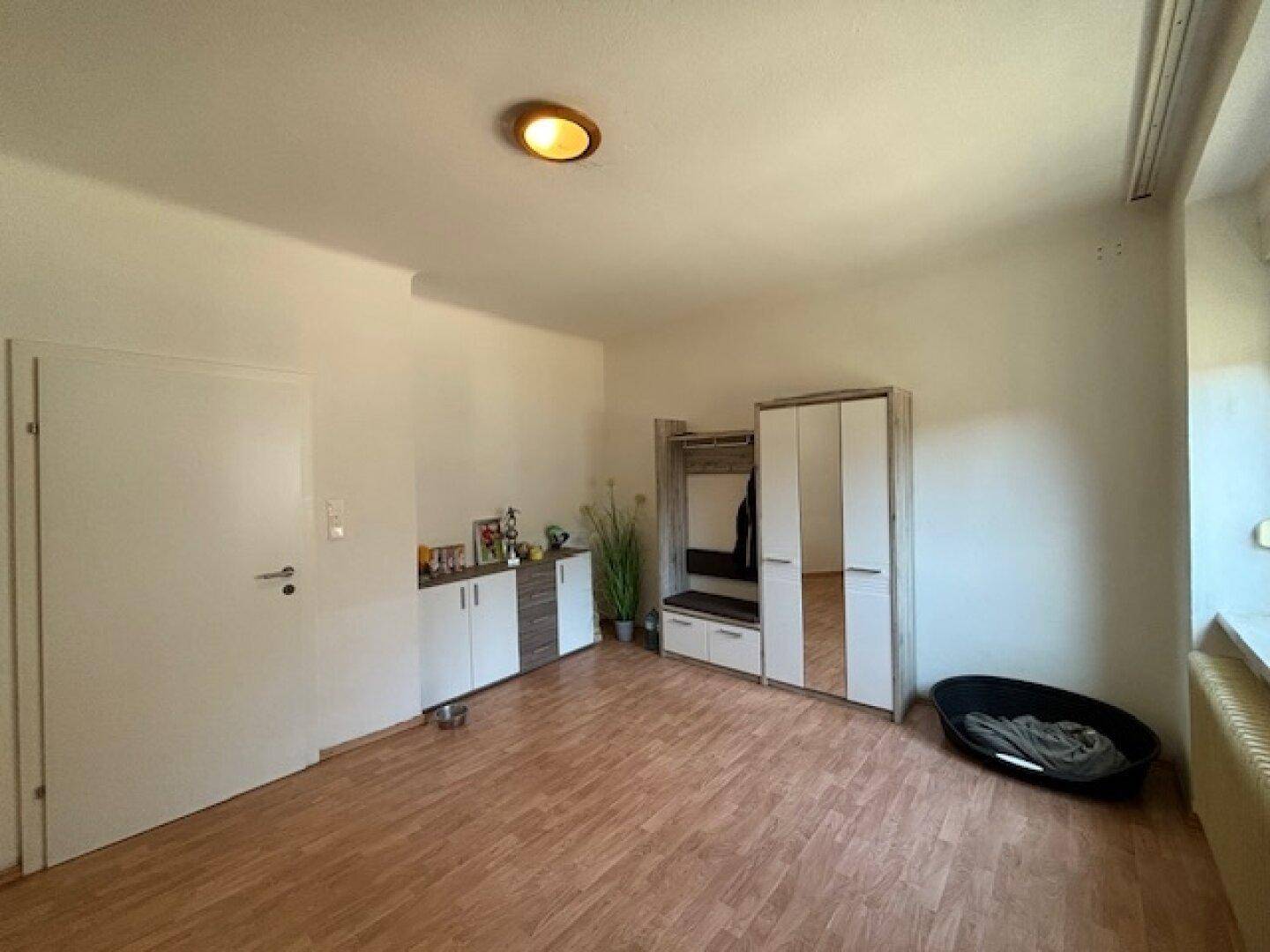 Heller Flur mit Laminatboden, Garderobe und Schränken, bereit zur individuellen Gestaltung.