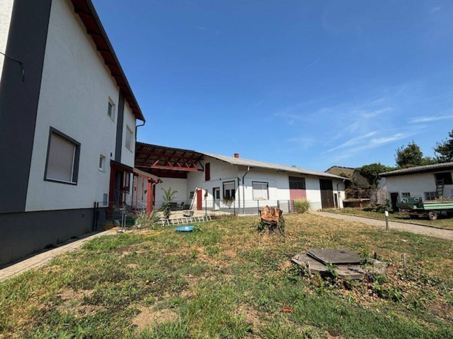 Gesamtansicht des Anwesens mit Wohnhaus, Nebengebäuden und weitläufigem Gartenbereich.