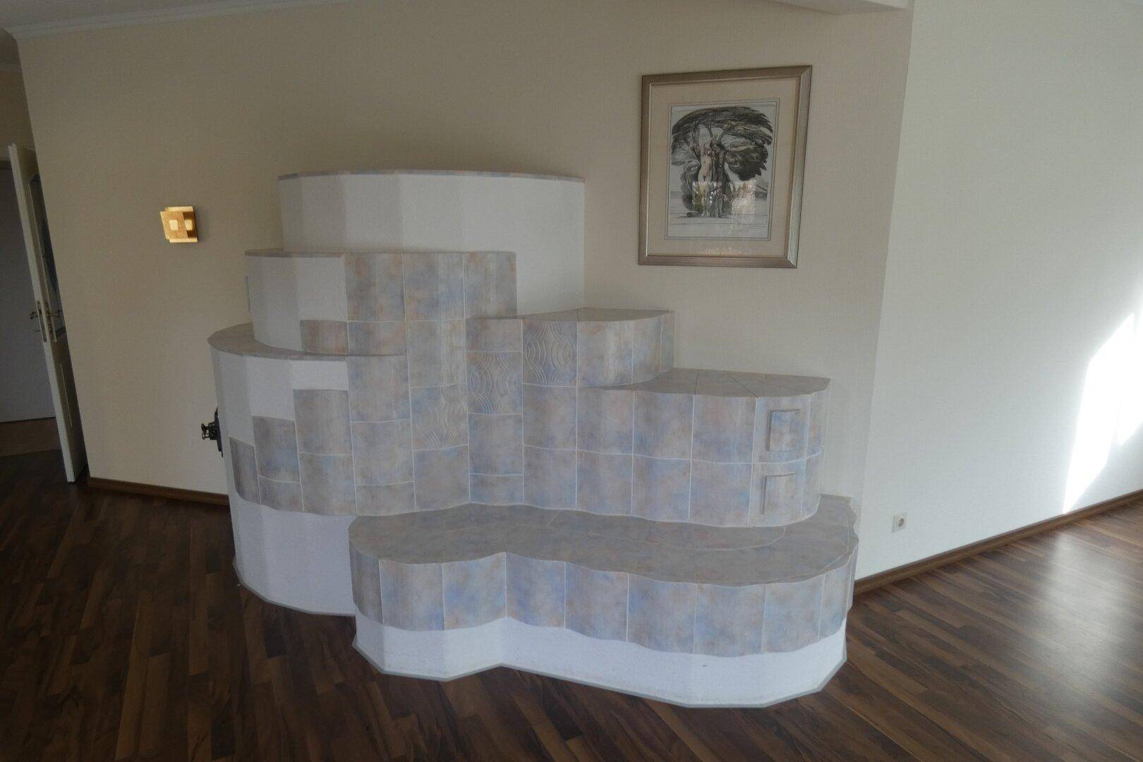 Traditioneller Kachelofen mit Sitzgelegenheit in einem hellen Wohnbereich mit Holzboden.