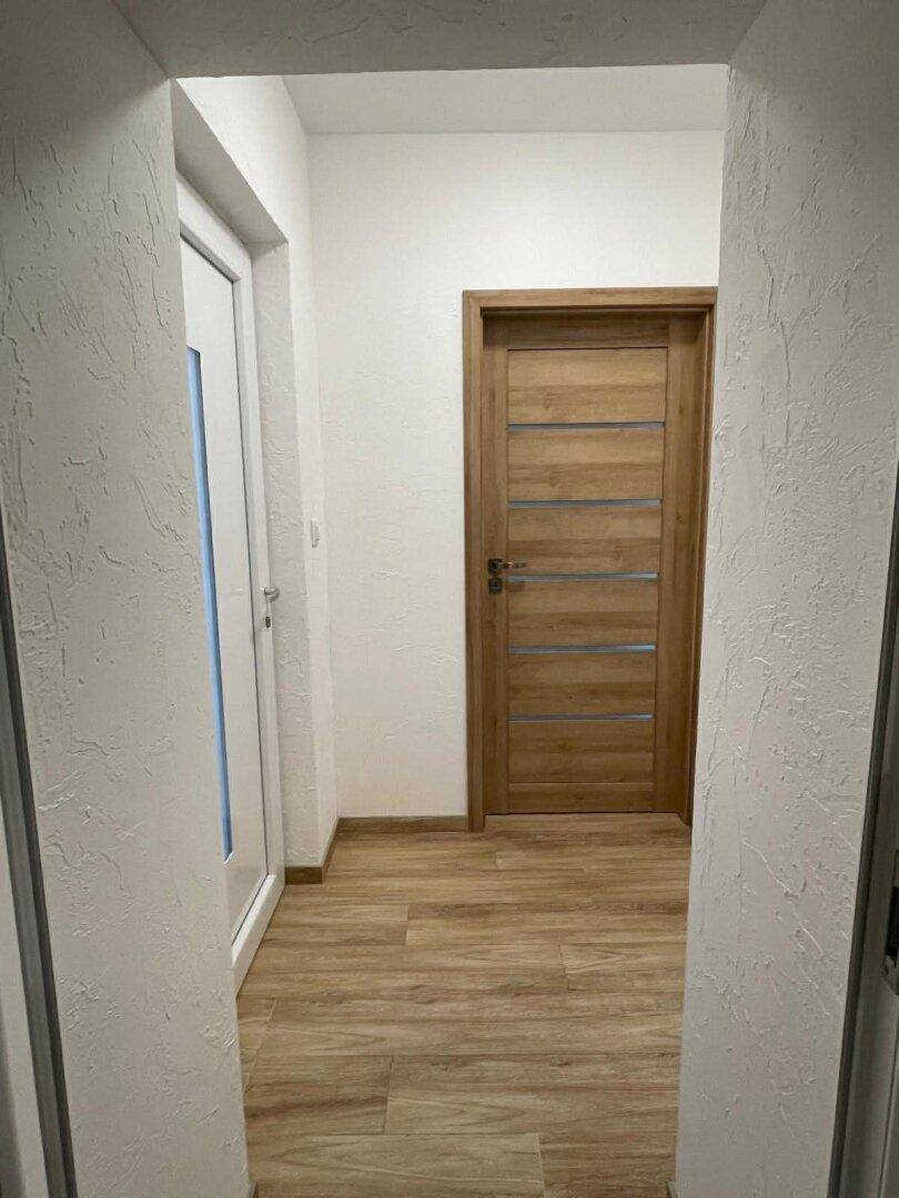 Heller Flur mit modernen Holztüren und pflegeleichtem Laminatboden.
