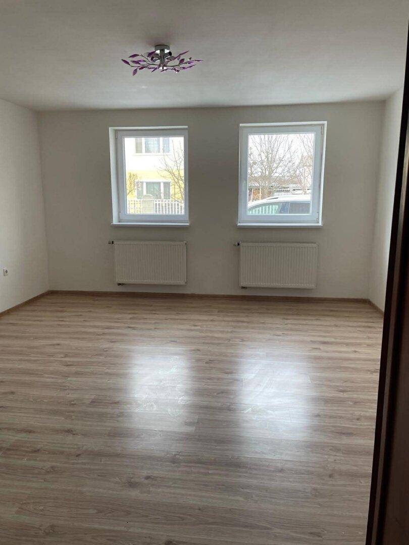 Geräumiges, helles Zimmer mit zwei Fenstern und neuem Laminatboden.