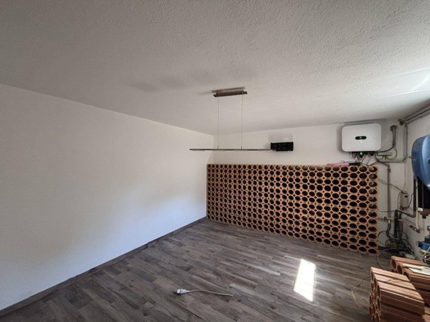 Kellerraum mit Weinregalen und technischer Ausstattung, ideal für Lagerung.