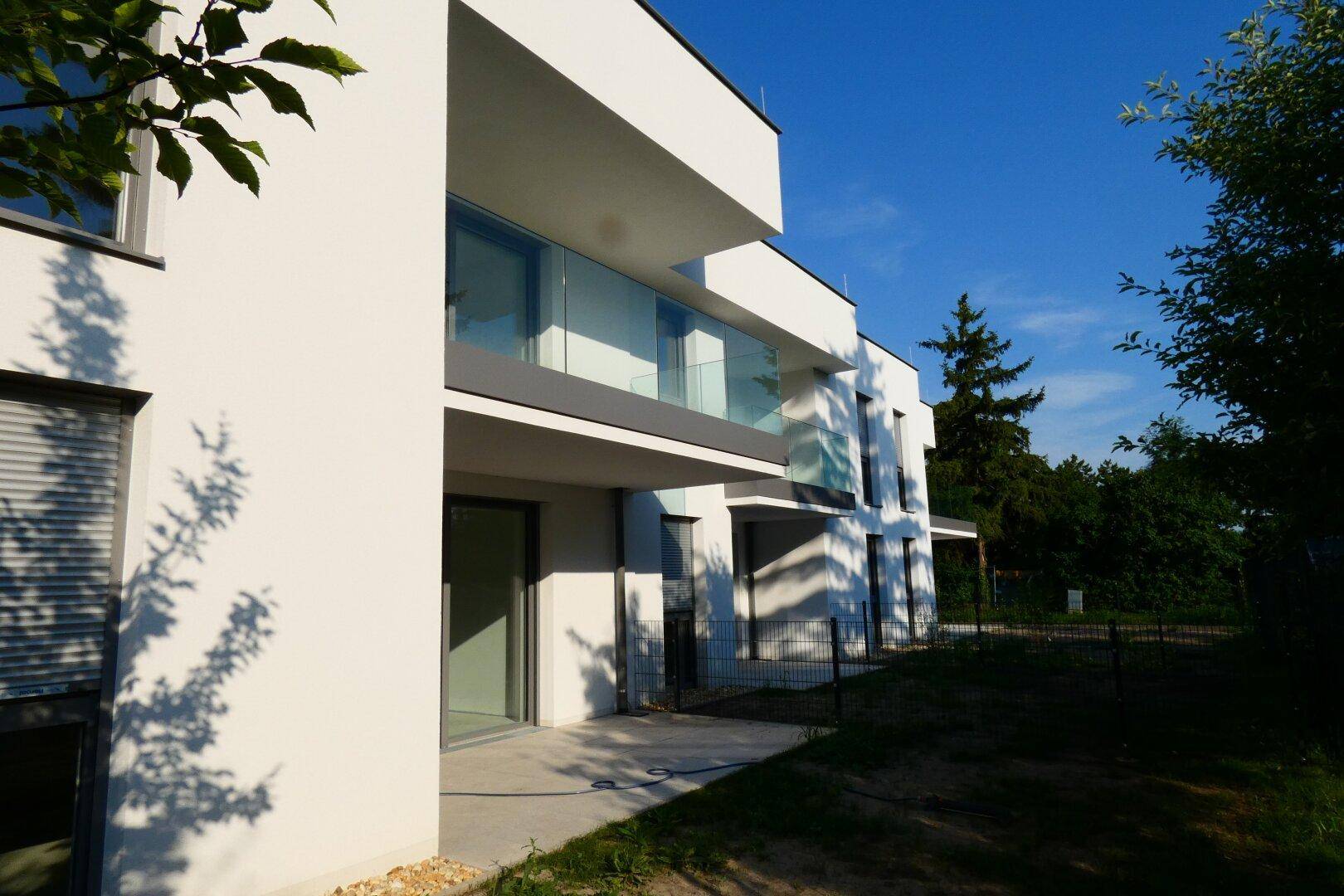 Die moderne Architektur des Gebäudes mit mehreren Balkonen und Terrassen, beleuchtet von der Abendsonne.