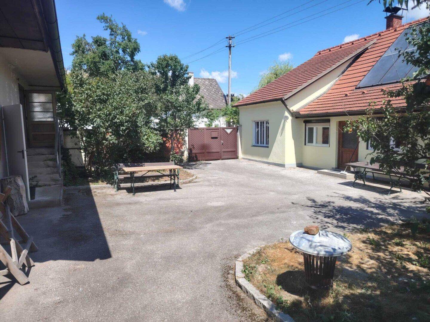 Großer gepflasterter Hofbereich mit Sitzgelegenheiten und Zugang zum Haus.