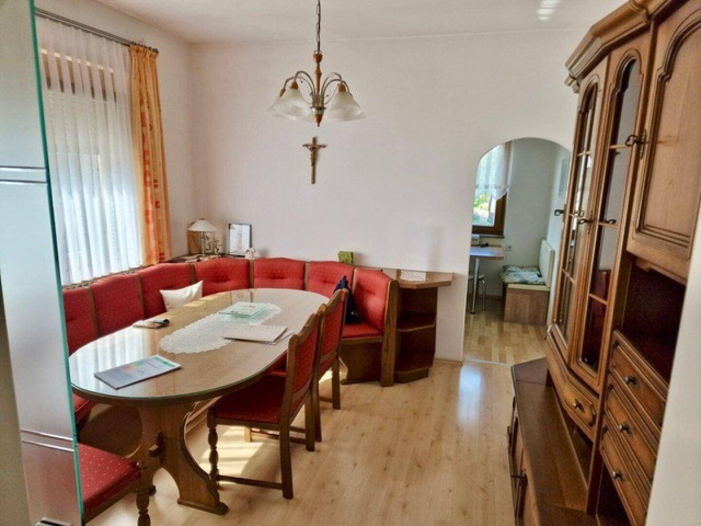 Gemütlicher Essbereich mit Eckbank, Holztisch und traditionellem Schrank, ideal für Familienmahlzeiten.