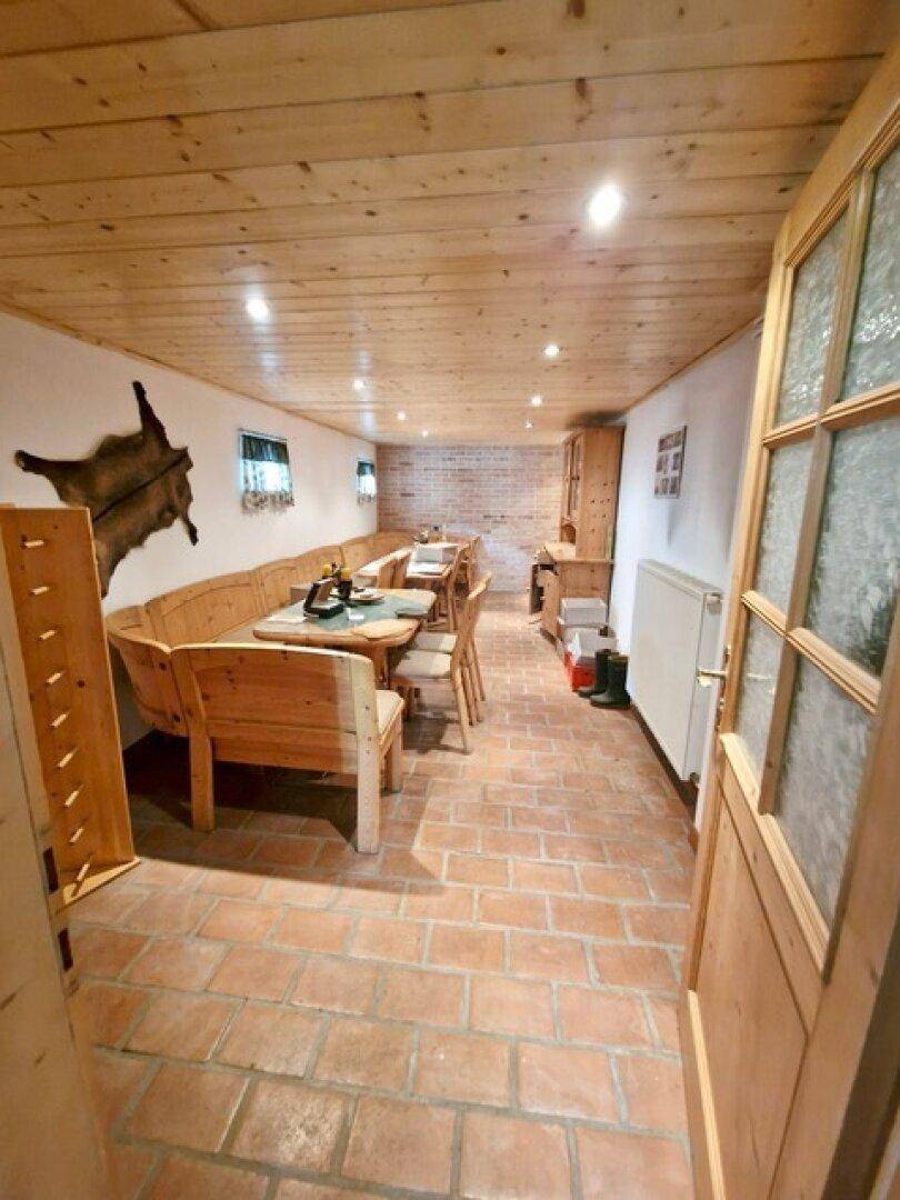 Rustikaler Essbereich mit Holzbänken, Holztäfelung und Terrakottaboden, ideal für gesellige Runden.