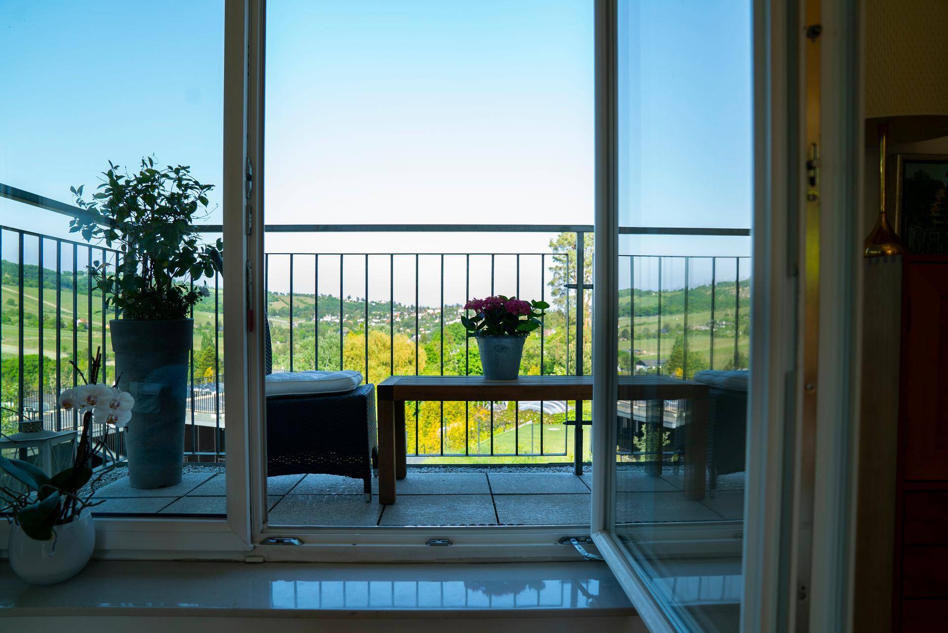 Balkon mit Fliesenboden und Blick auf die grüne Landschaft, ideal für entspannte Stunden im Freien.